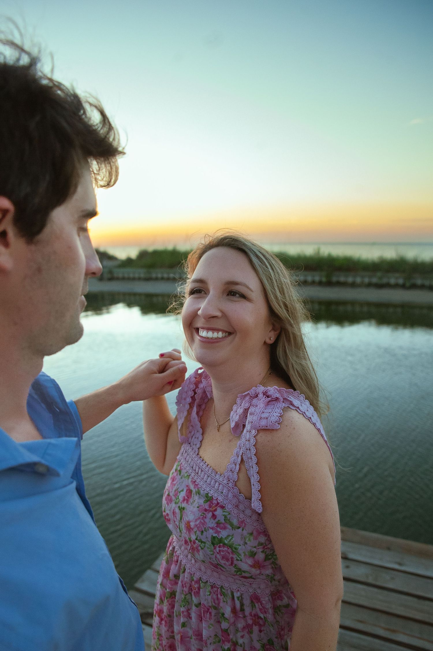 Romantic sunset moment captured on wooden dock by water.