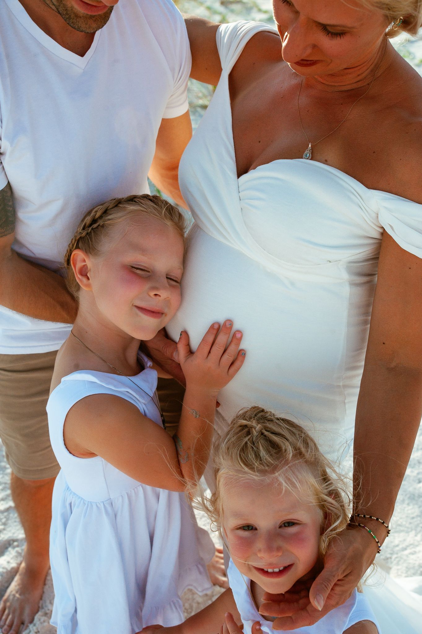 A series of five candid family photos showing tender moments between people in white clothing outdoors.