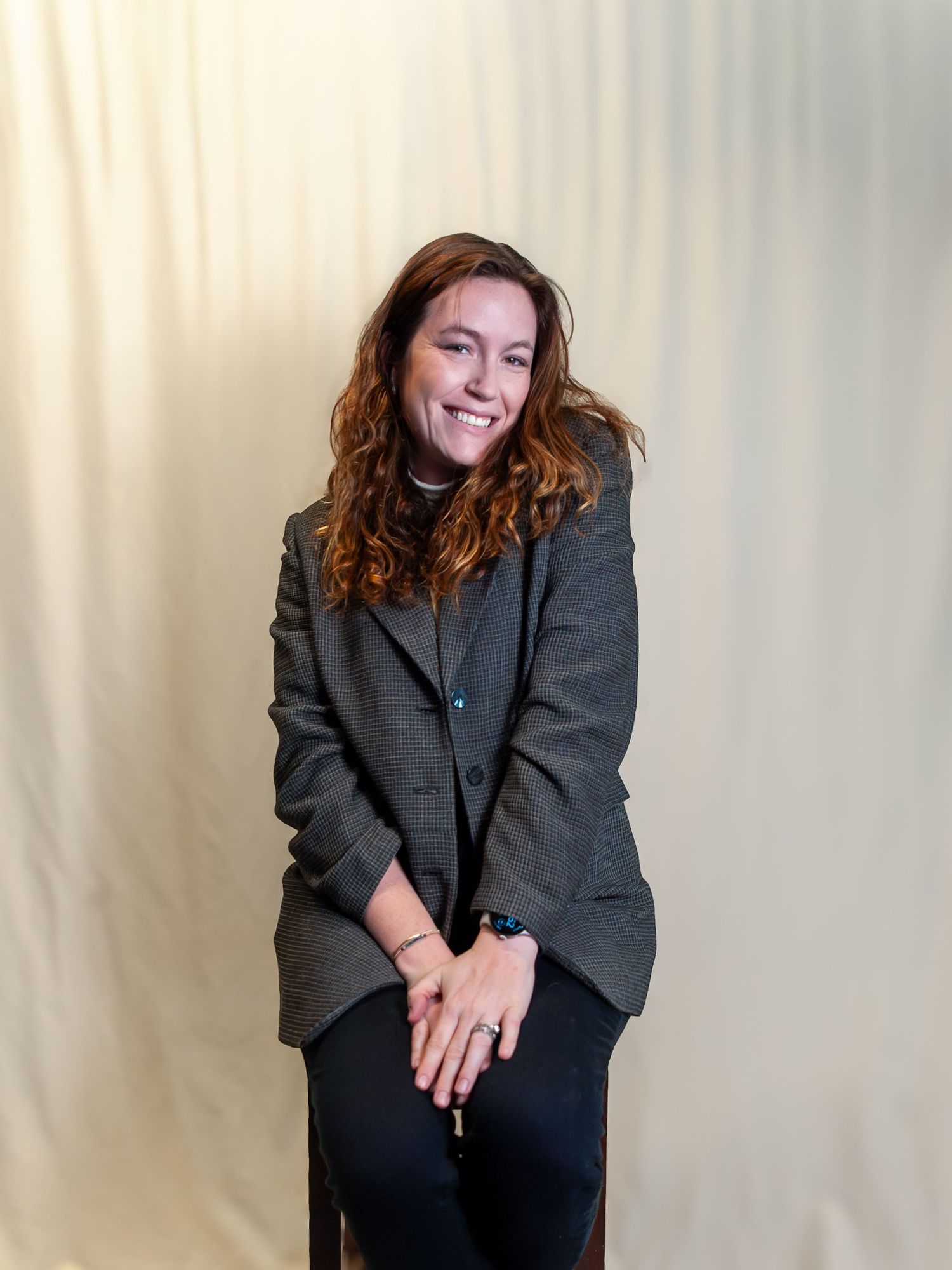 Professional portrait series showing a person in a dark blazer against a light backdrop in four candid poses.
