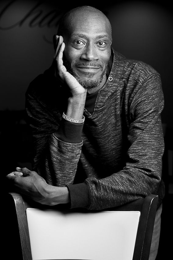 A monochromatic photo series showing someone in a gray sweater posing against a dark background.
