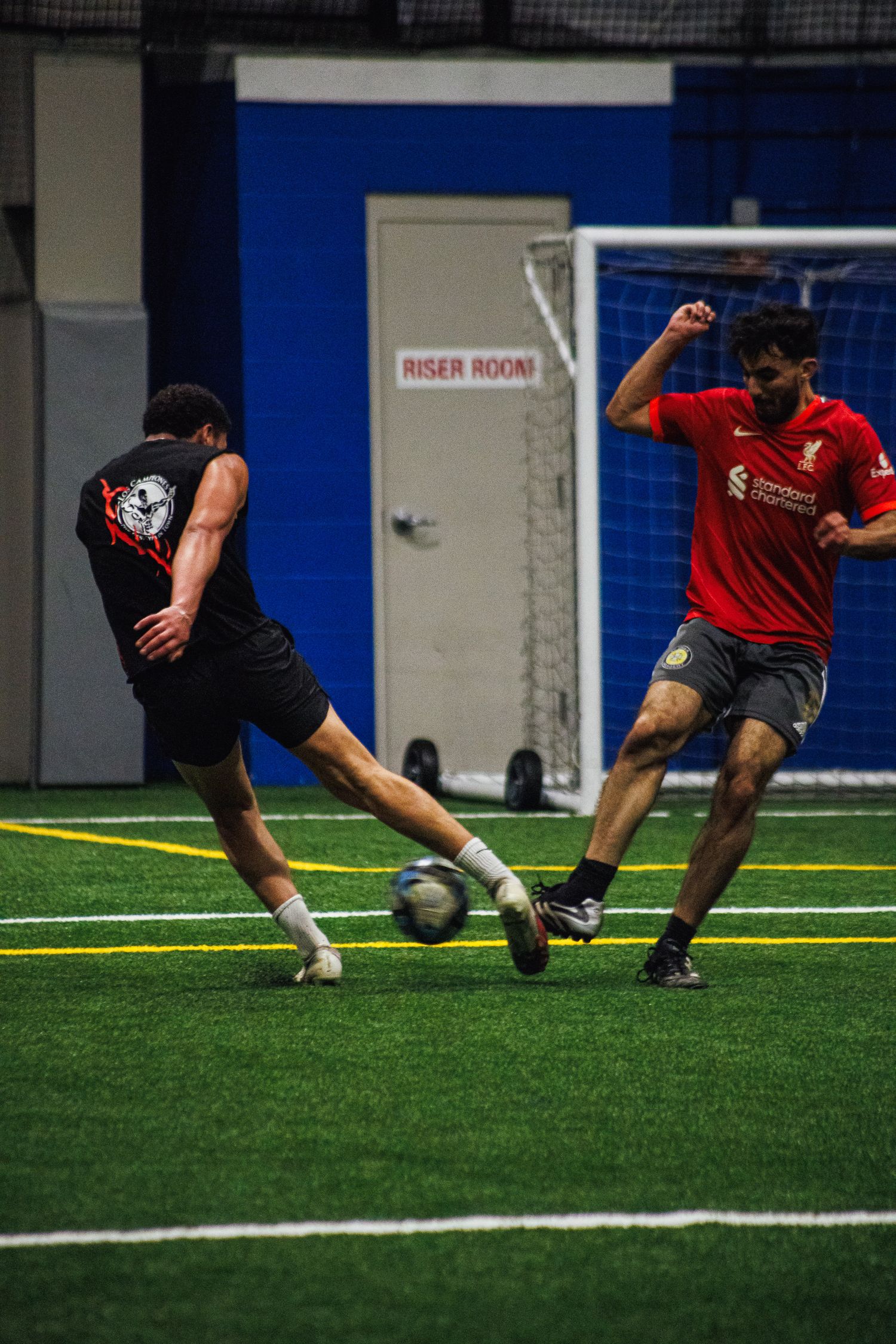 Striker lining up a shot on goal in an indoor Twin Cities soccer match