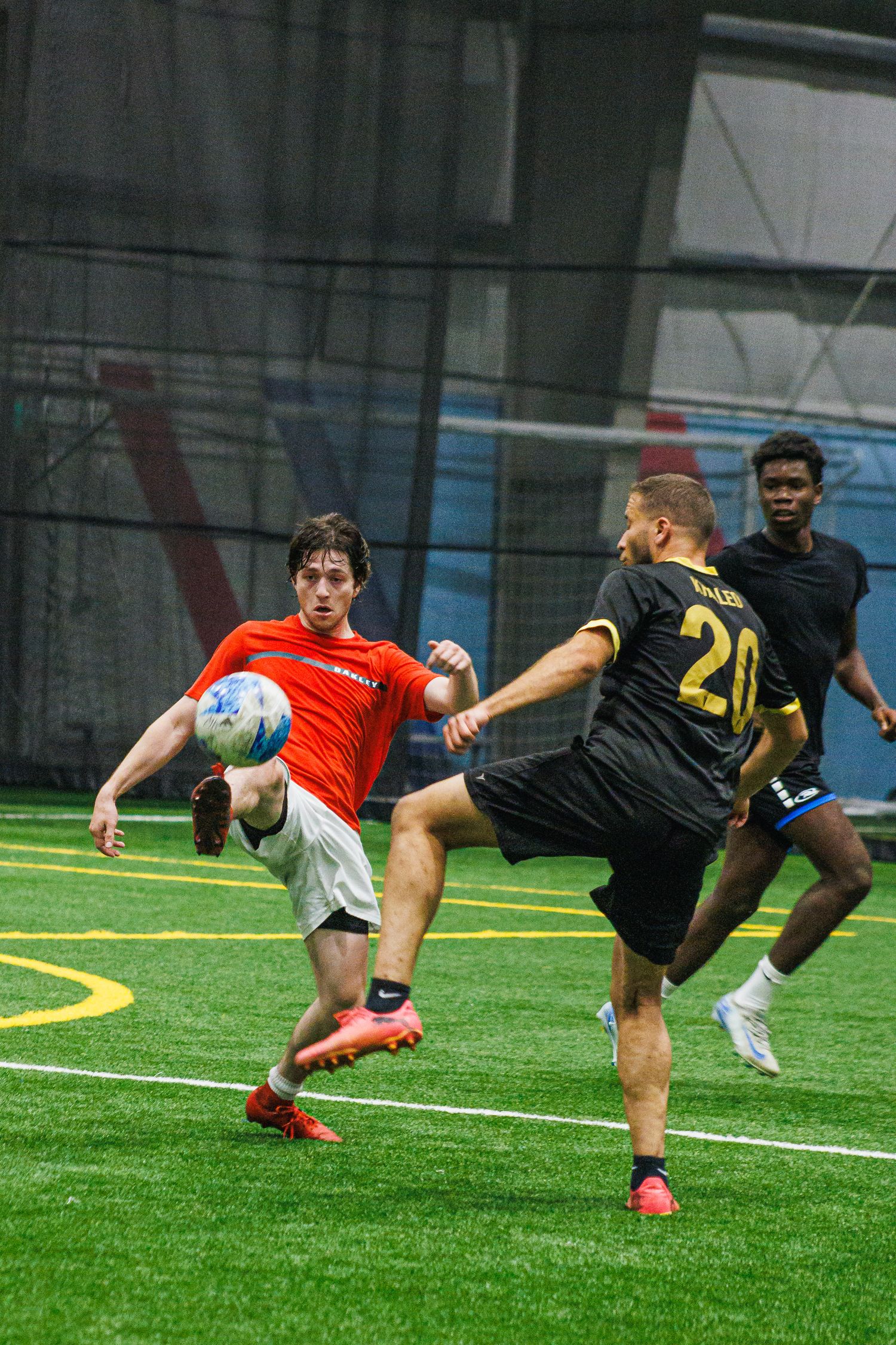 Defender and attacker contesting the ball in a Twin Cities indoor soccer game
