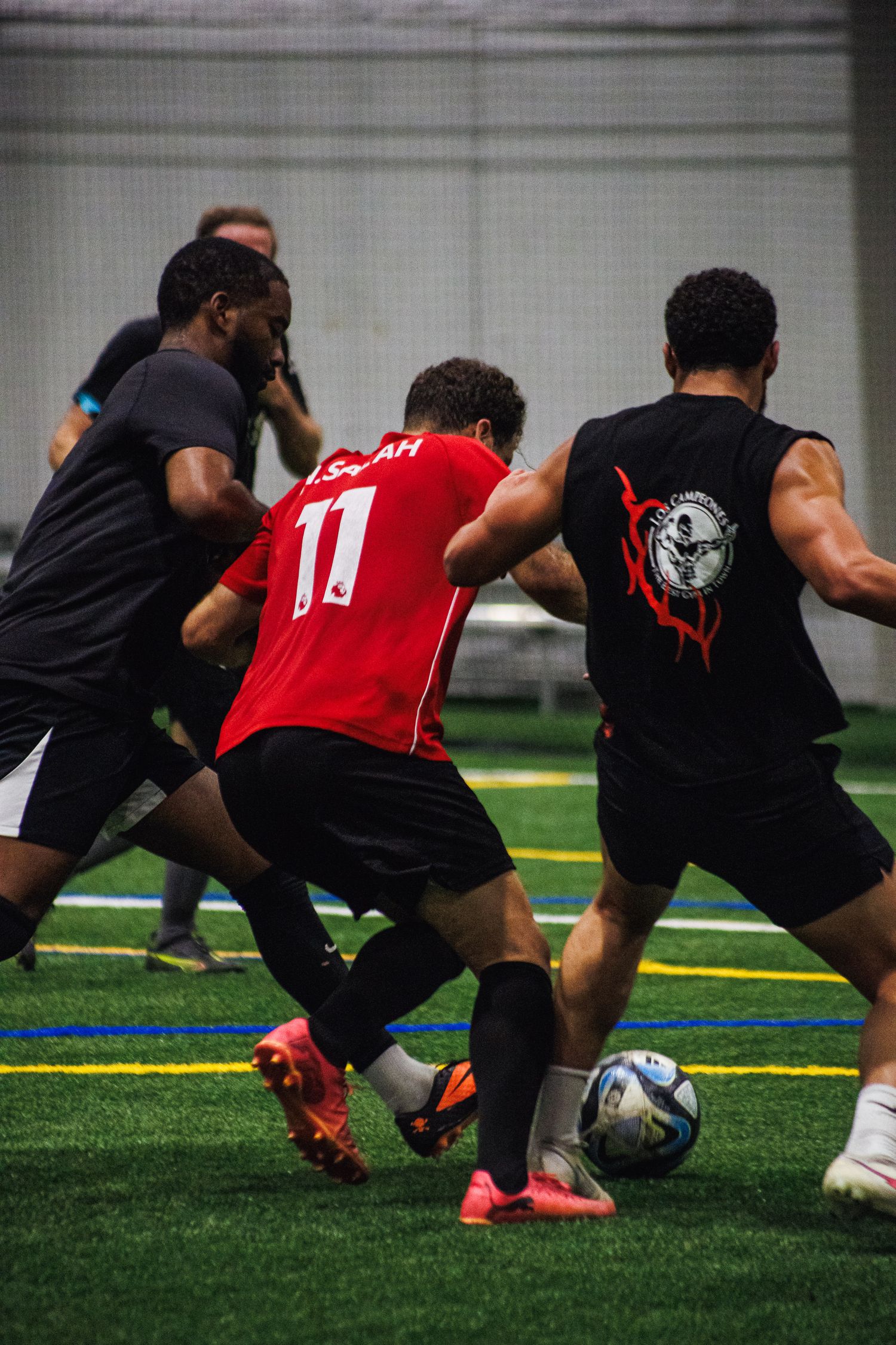 Players shielding the ball during an indoor Minneapolis soccer game
