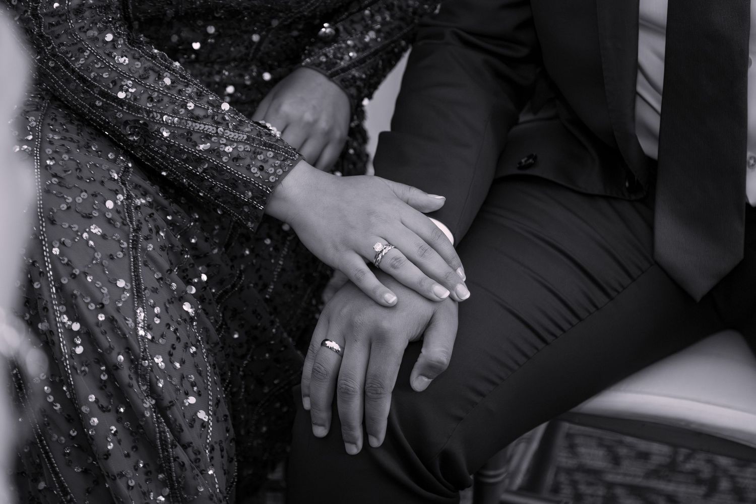 Engagement couple holding hands after exchanging rings - black and white photo.