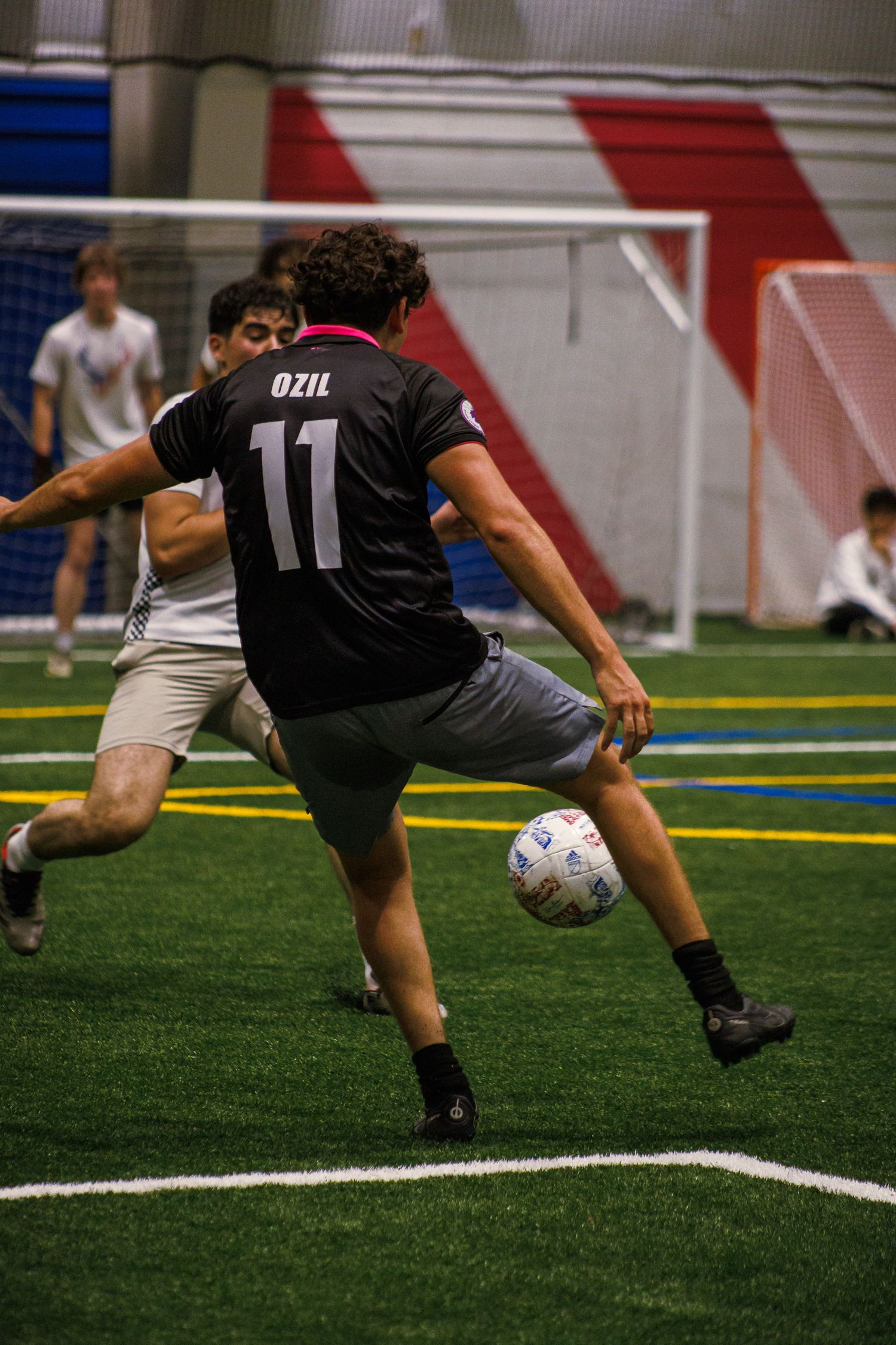 Soccer player dribbling the ball upfield during an indoor Twin Cities matchPlayers battling for a high ball during an indoor Twin Cities soc