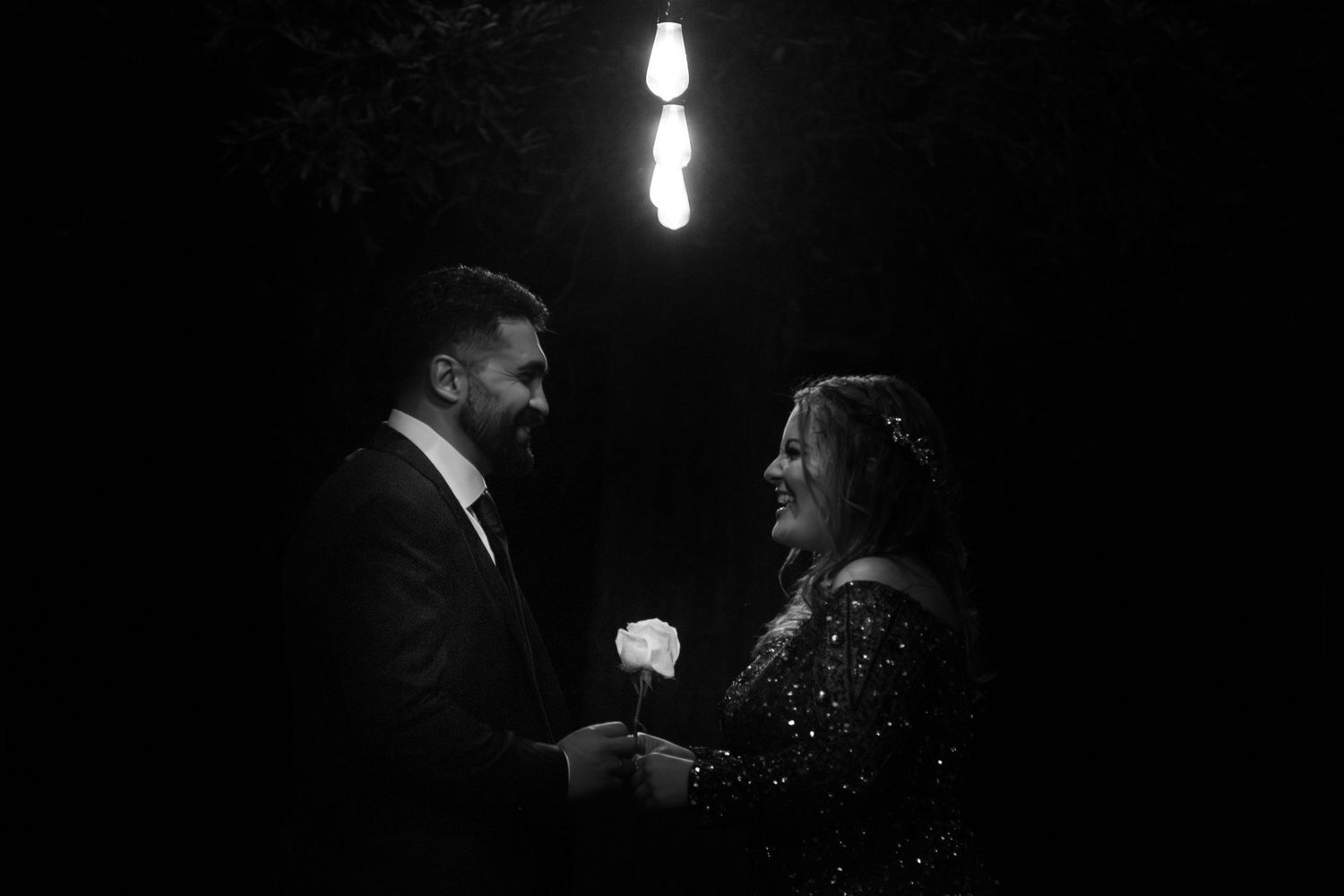 Couple after engagement party under light - black and white photo.