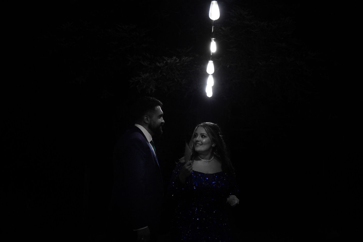 Couple after engagement party under light - black and white photo.