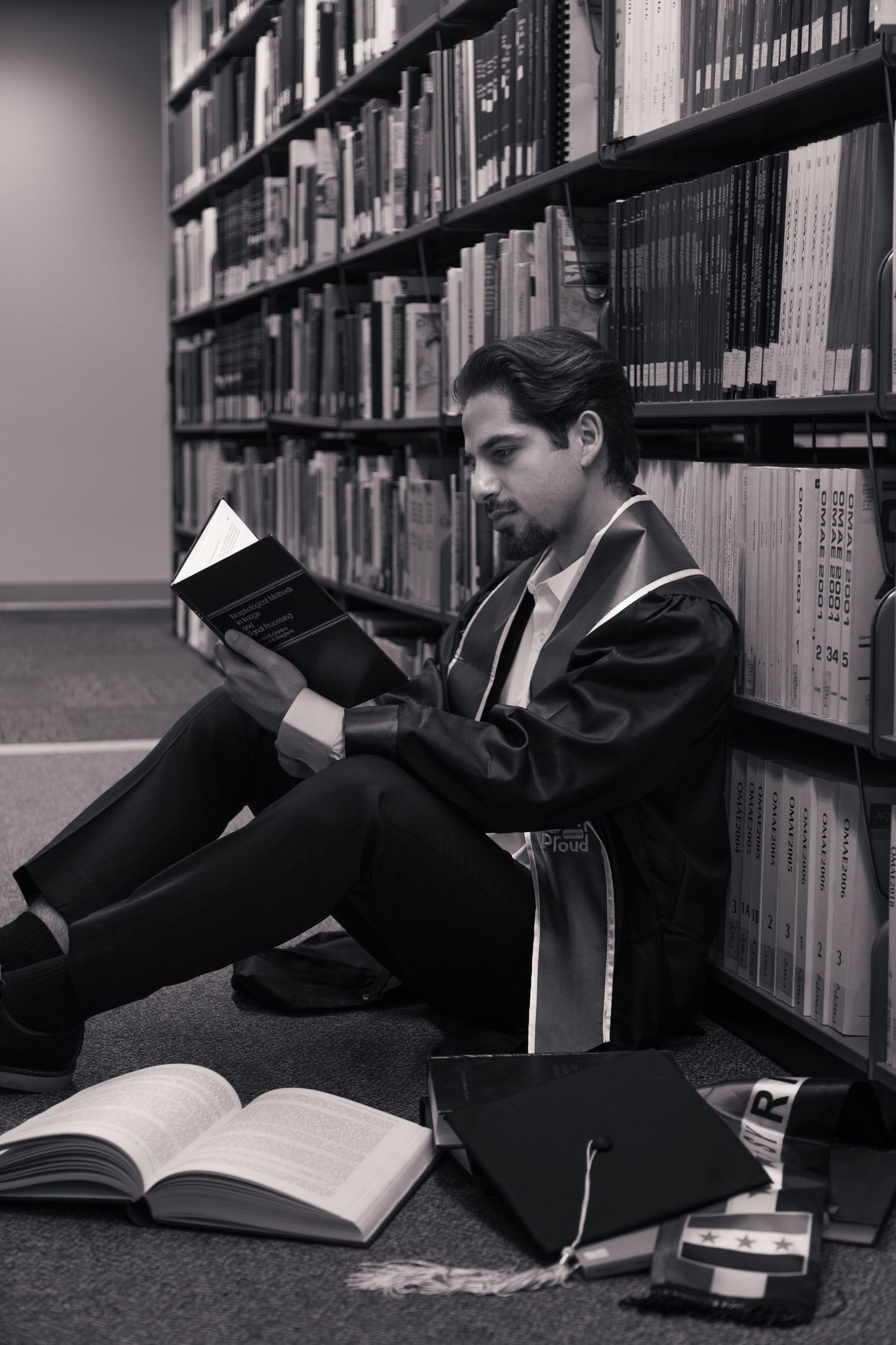 Graduation portrait of student taken at the University of Minnesota Twin Cities - black and white photo in library.