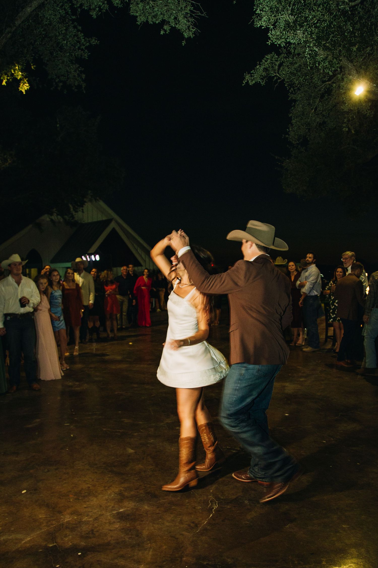 Couples dancing at an outdoor wedding reception.