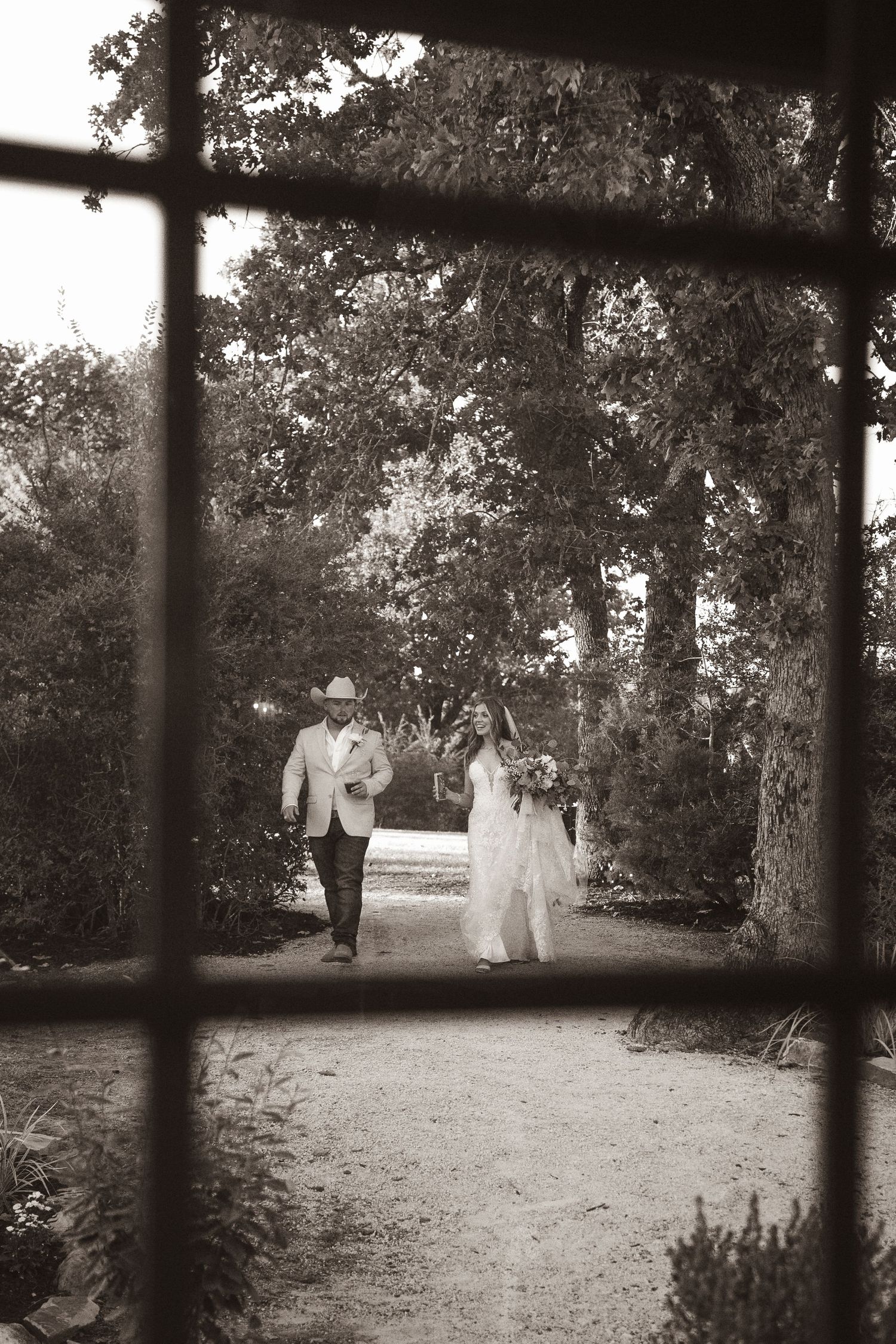 Dreamy black and white wedding scene viewed through window frames.