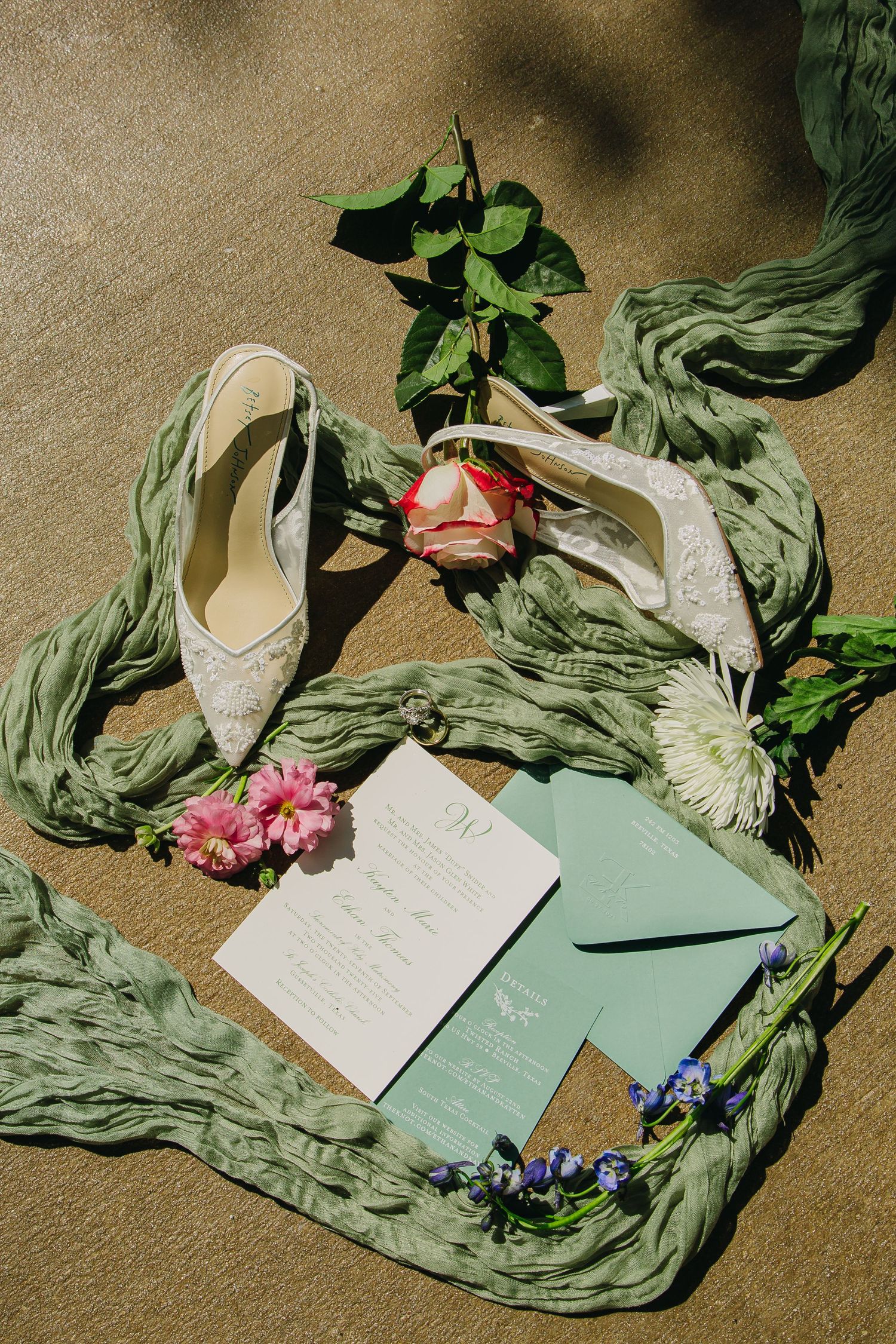Elegant wedding stationery layout with mint green cards, white lace, and pink floral accents.