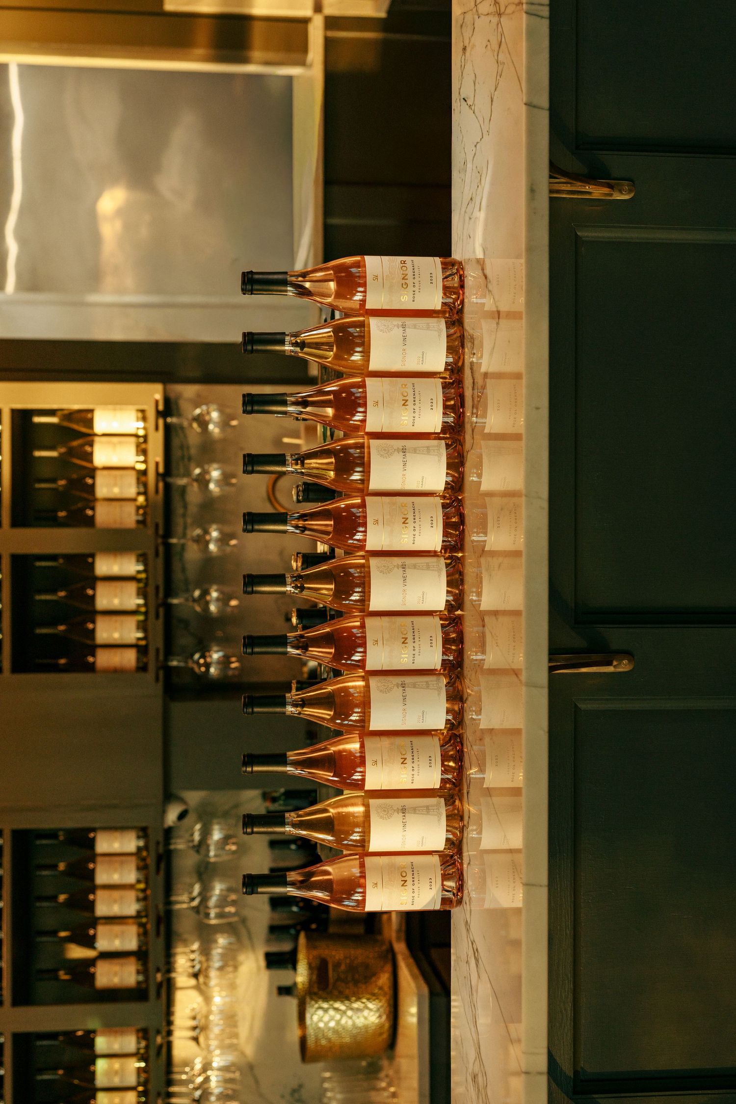 Wine bottle display rack mounted on wall showing organized collection of vintages.
