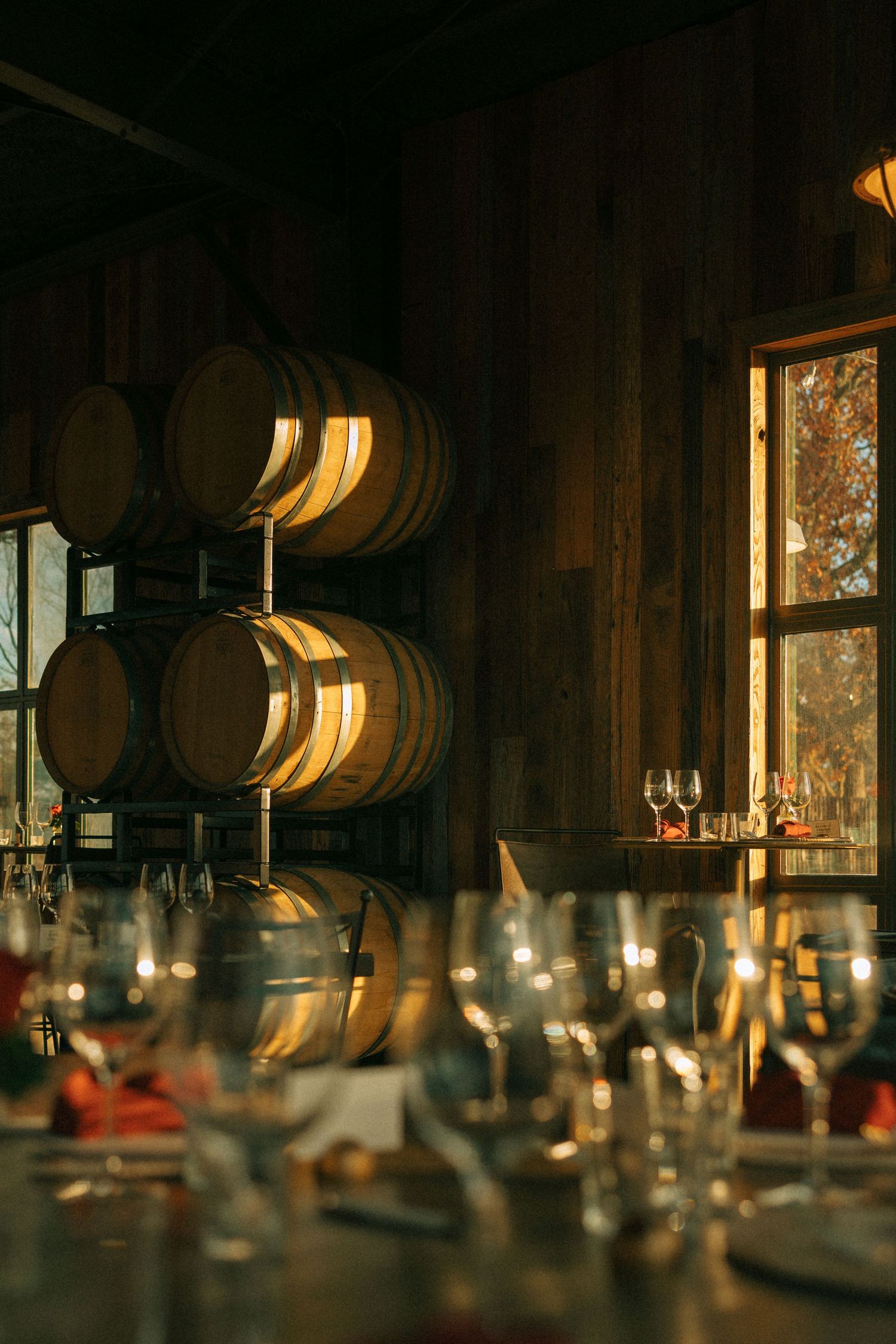 Rustic wine barrel room with warm lighting and elegant table settings.