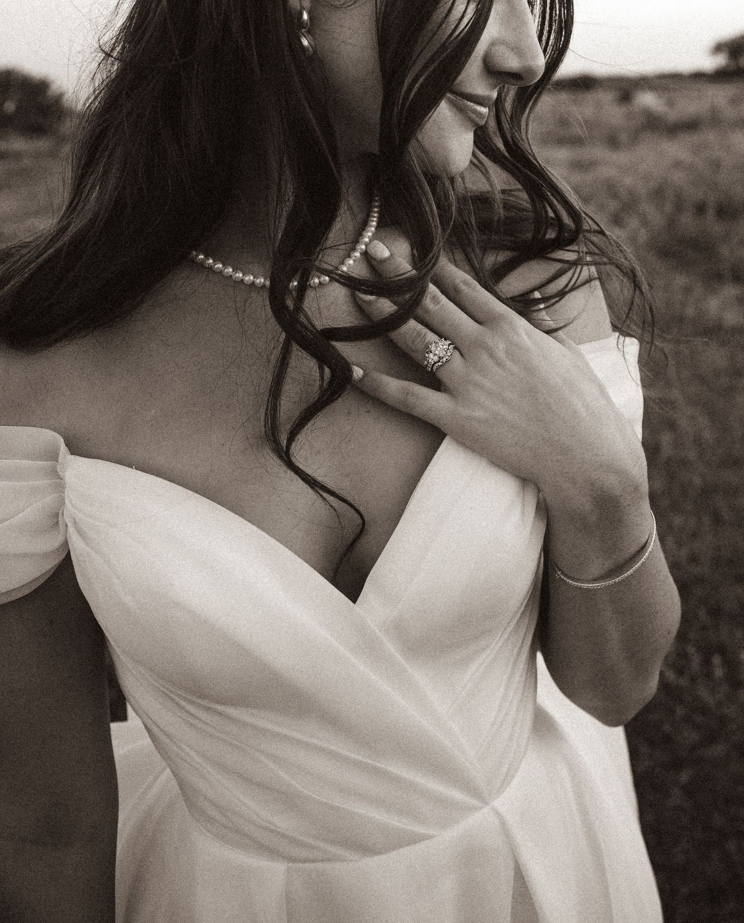 Close-up details of an off-shoulder white wedding dress with delicate fabric.