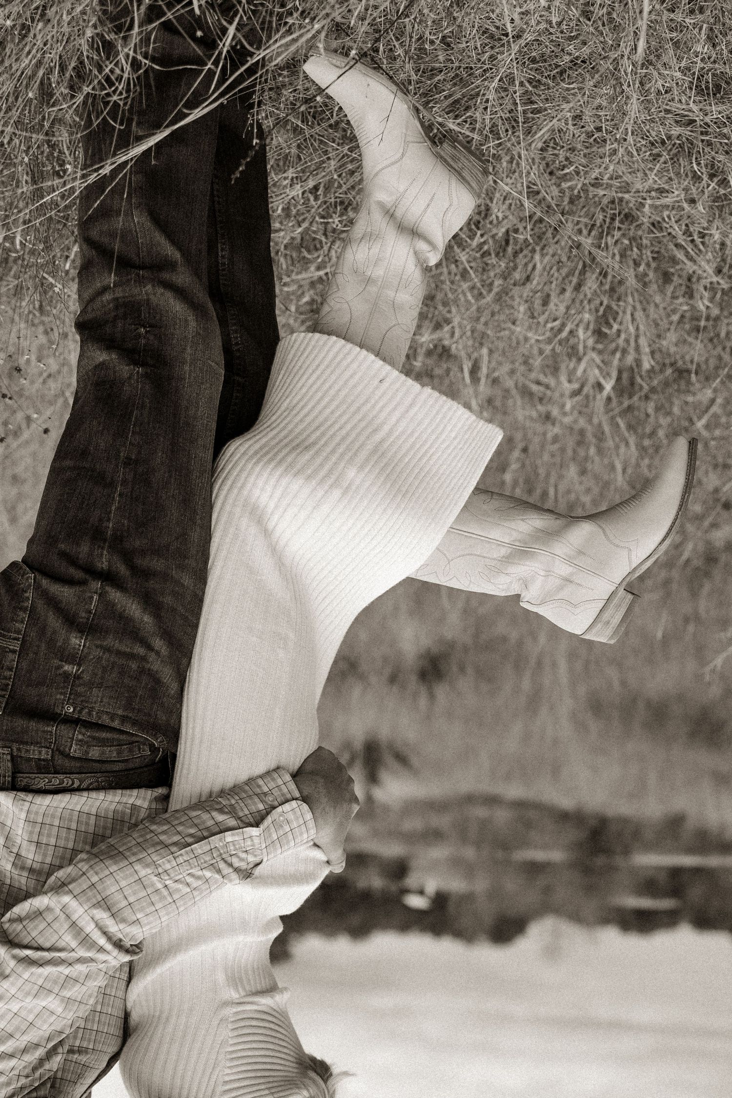 A monochrome detail shot of white boots and jeans during an intimate moment.