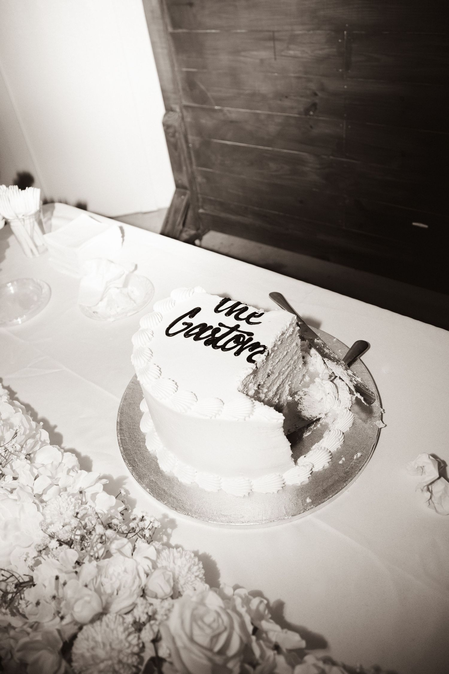 Black and white artistic close-up of partially eaten wedding cake.