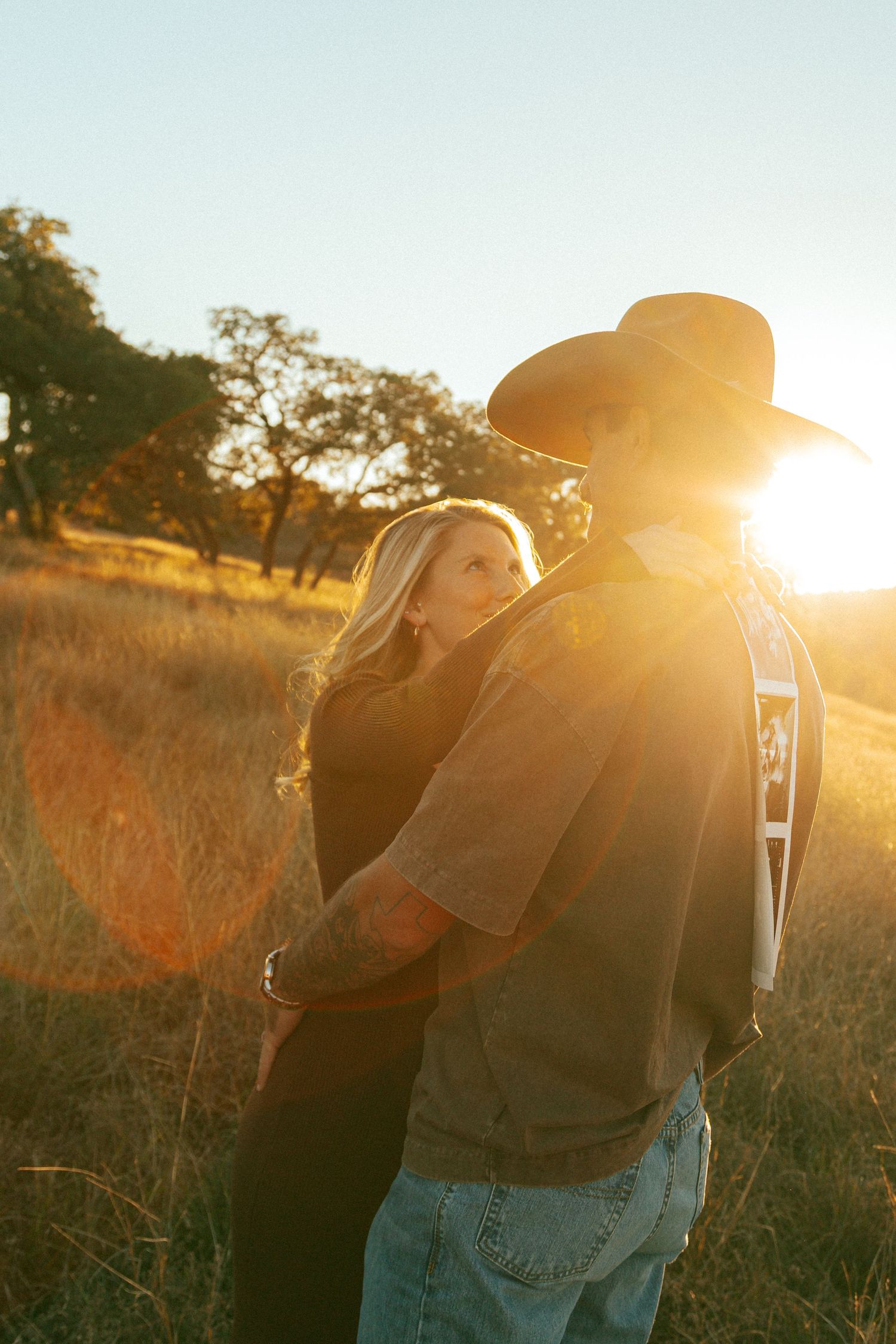 Golden hour portrait session in a rustic field with backlit sunset glow.