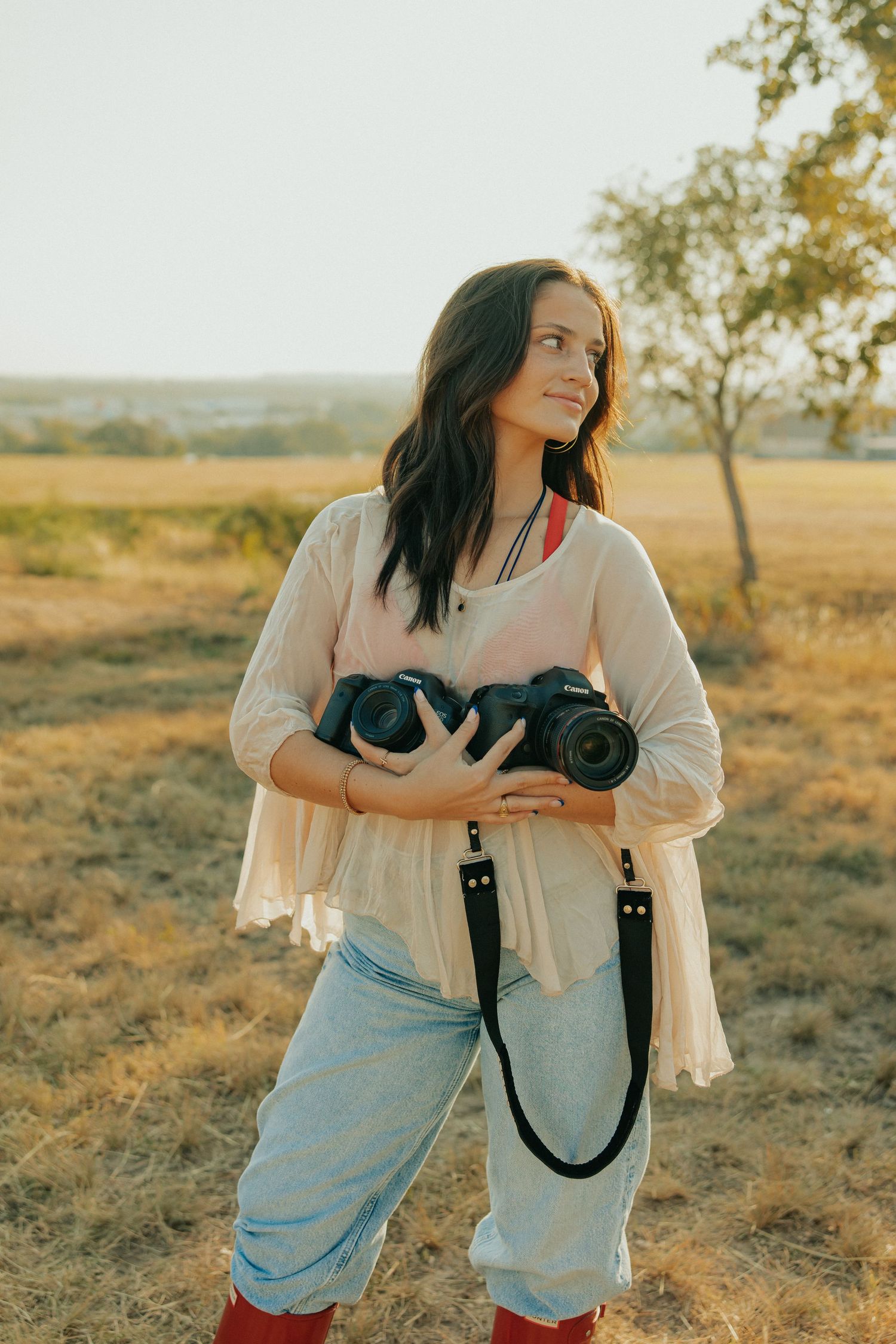 Candid moments of photographer with camera during sunset field session.