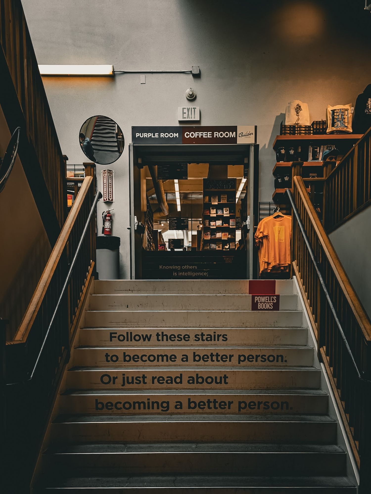 Staircase at Powell's Books with motivational text reading Follow these stairs to become a better person or just read about it.