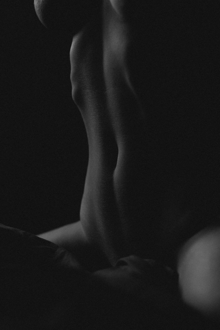 Photographie artistique en noir et blanc, mettant en valeur le ventre tonique et les courbes d'un corps féminin.