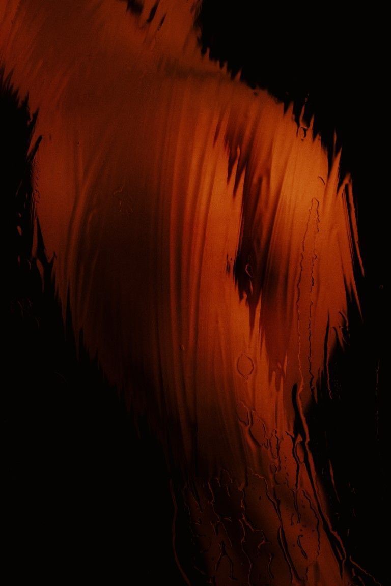 Abstract dark background with glowing orange and red fluid brushstroke textures creating a dramatic fiery artistic effect.