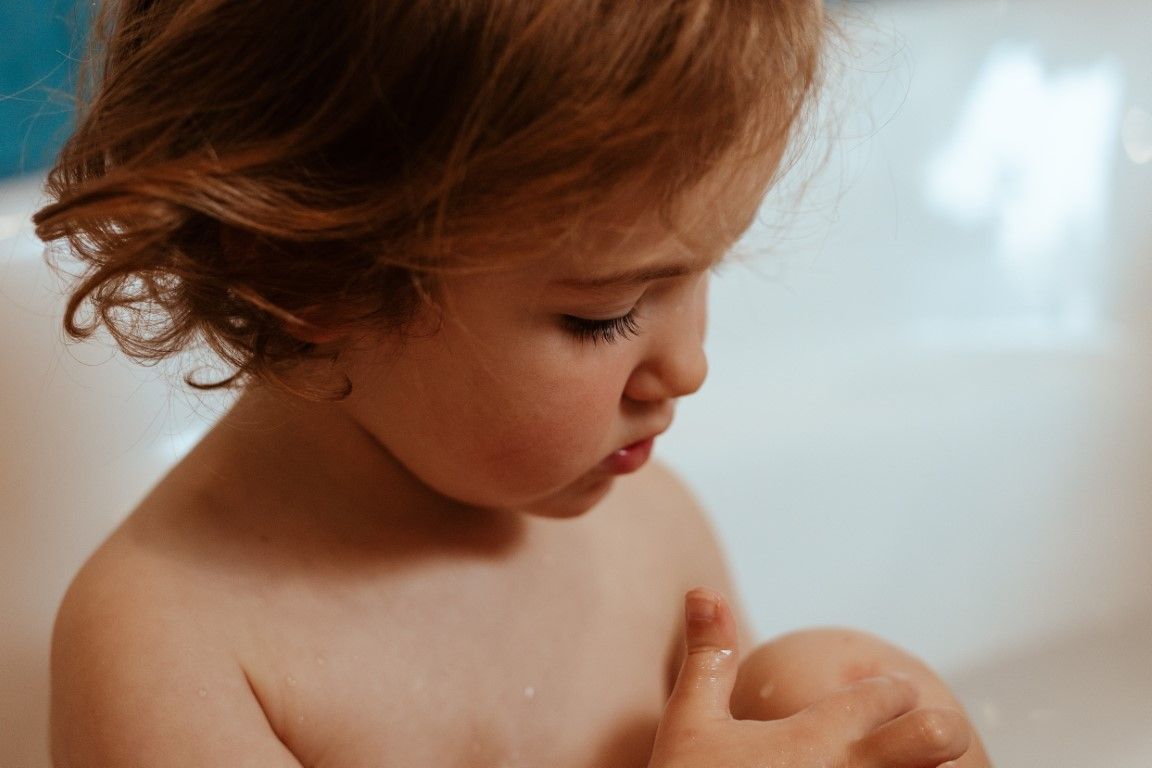 Gros plan sur le visage d'une petite fille prenant son bain en basse normandie.