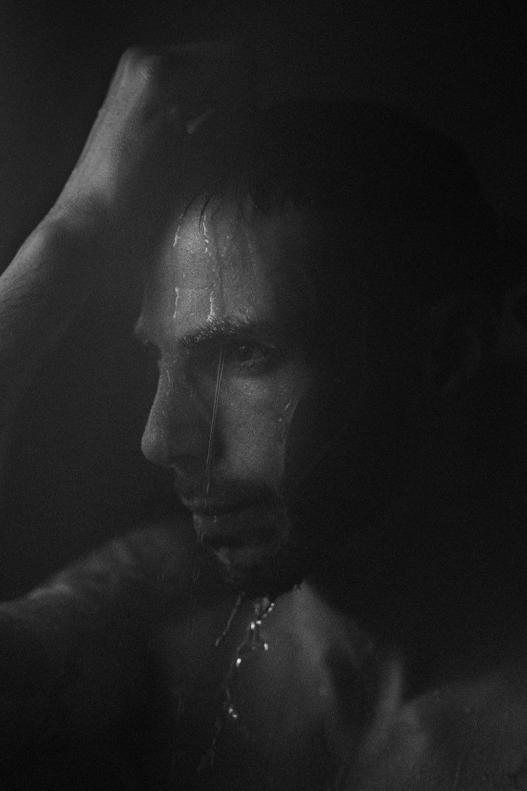 Portrait dramatique en noir et blanc d'un homme dont le visage est ruisselant d'eau.