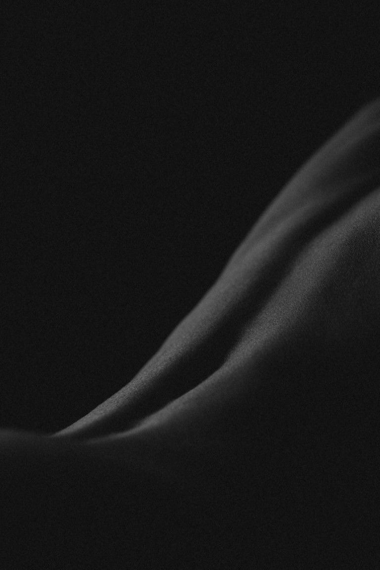 Photo en noir et blanc d'un nu artistique féminin du courbe du bas du dos.