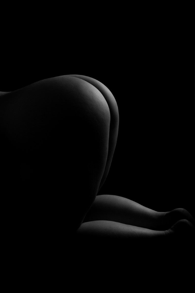 Photographies artistiques de nus en noir et blanc mettant en valeur des courbes corporelles avec un éclairage tamisé sur fond noir