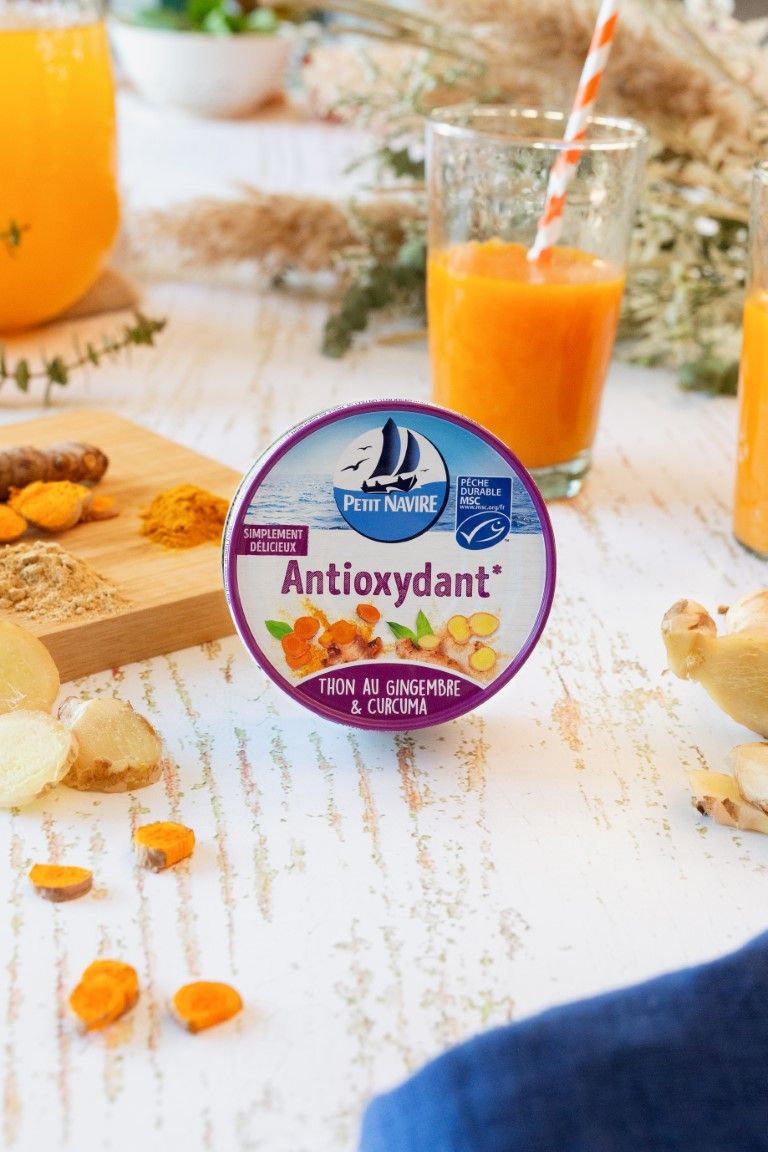 Petit Navire Antioxydant tuna can with ginger and turmeric beside fresh juice and ingredients.