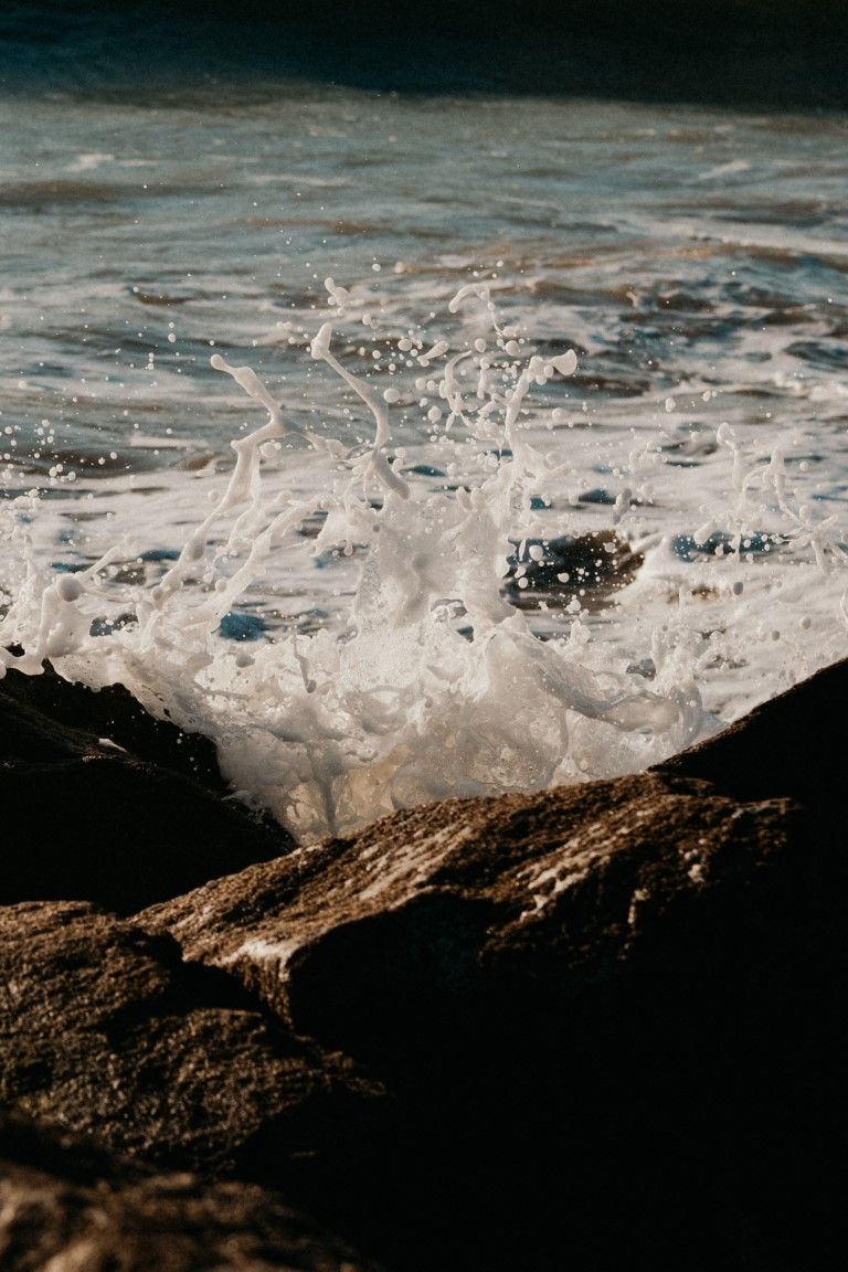 Les vagues de la Manche s'écrasent et s'écrasent avec fracas sur les rochers sombres par une journée ensoleillée.