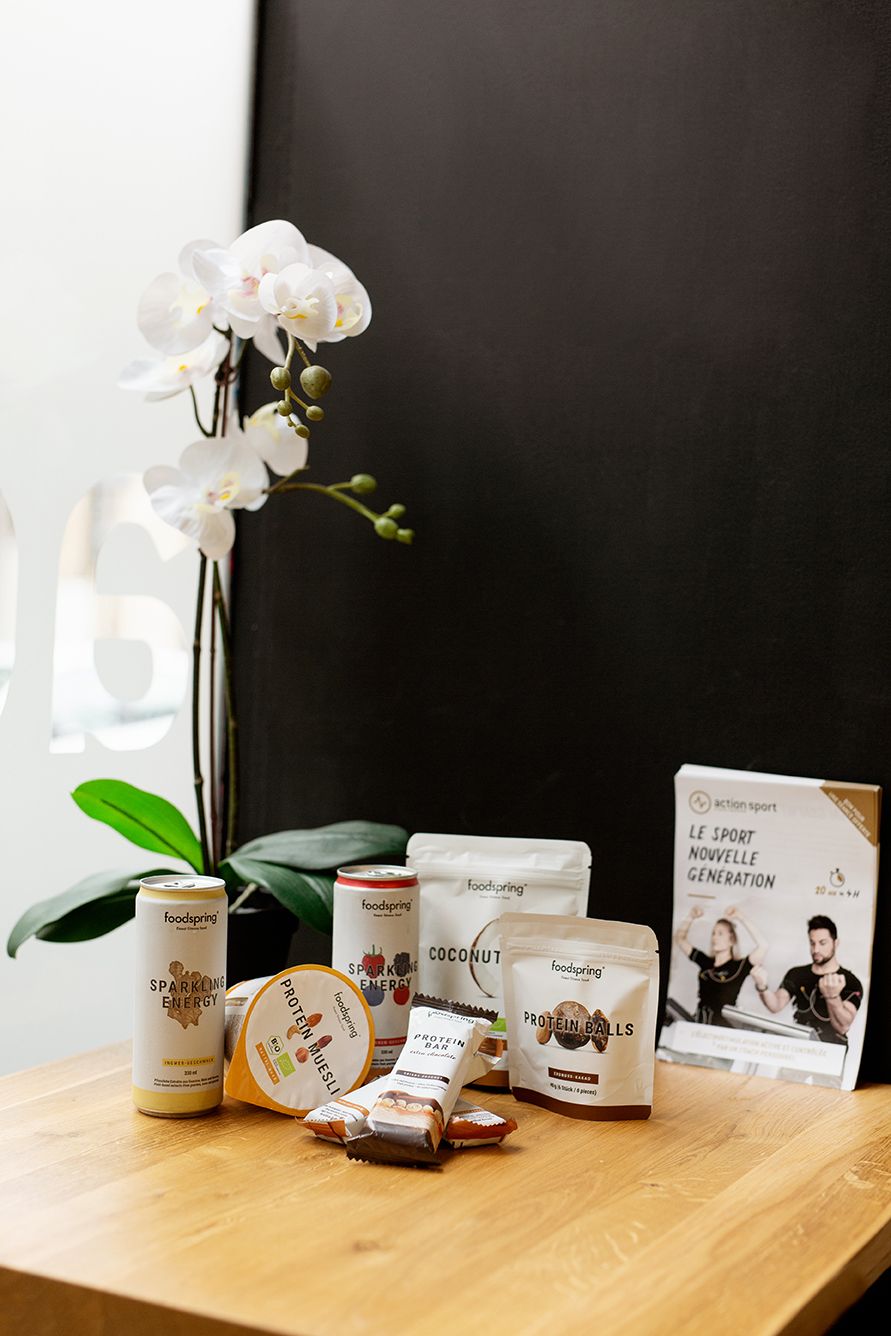 Healthy snacks and supplements displayed on wooden table with white orchid and black background.