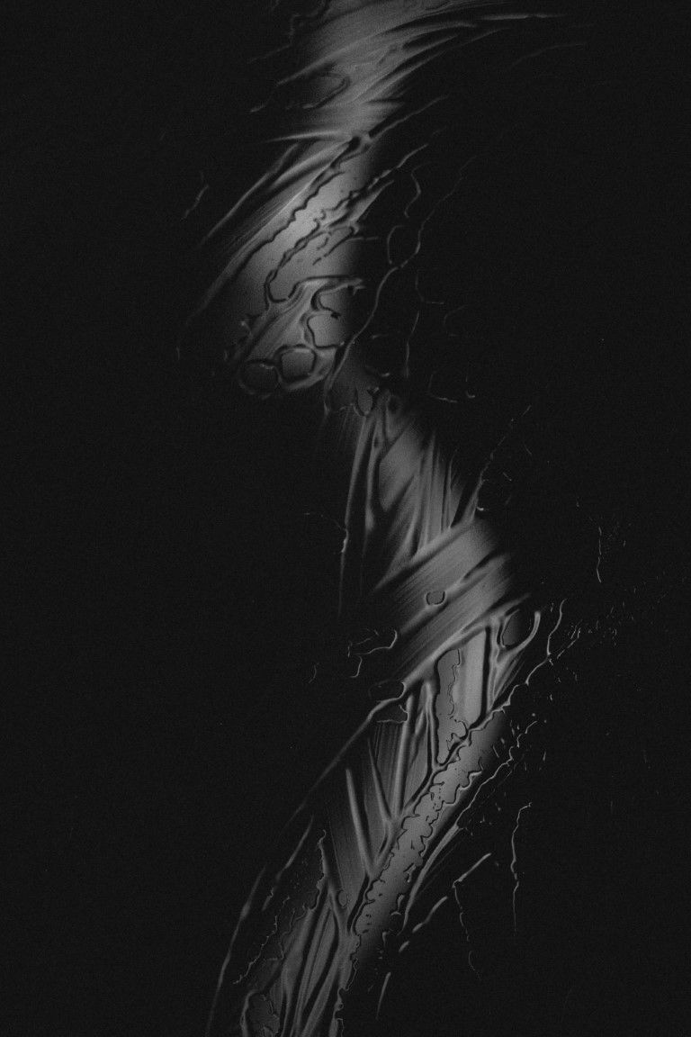 Silhouette abstraite de nu en noir et blanc, enveloppée dans une texture de plastique craquelé sur fond sombre.