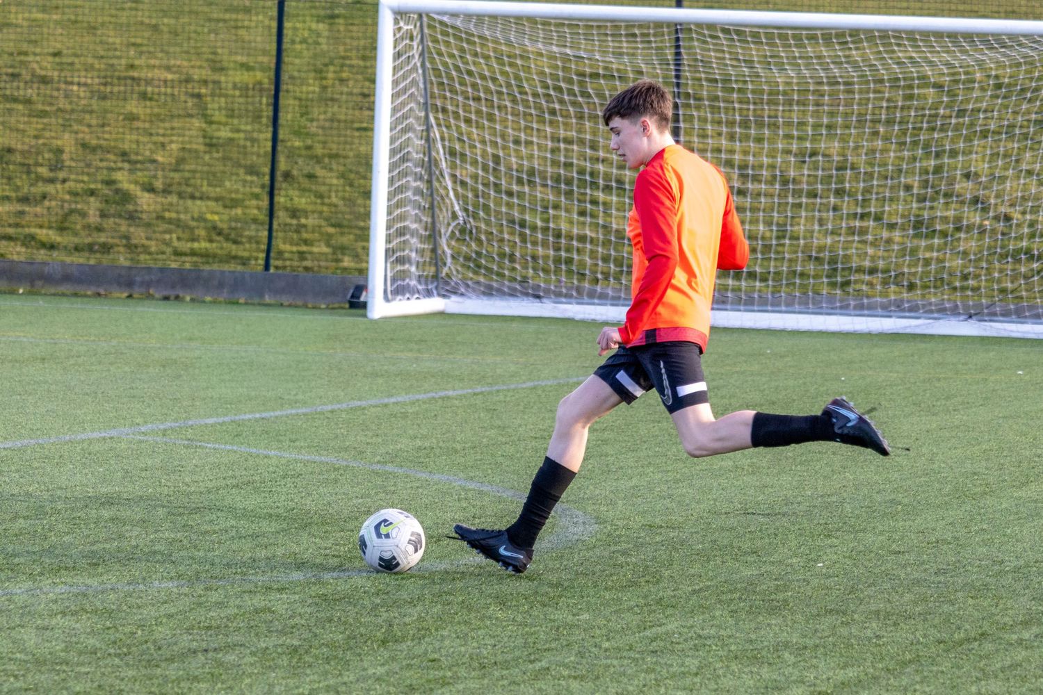 Braes High School football player kicking the ball