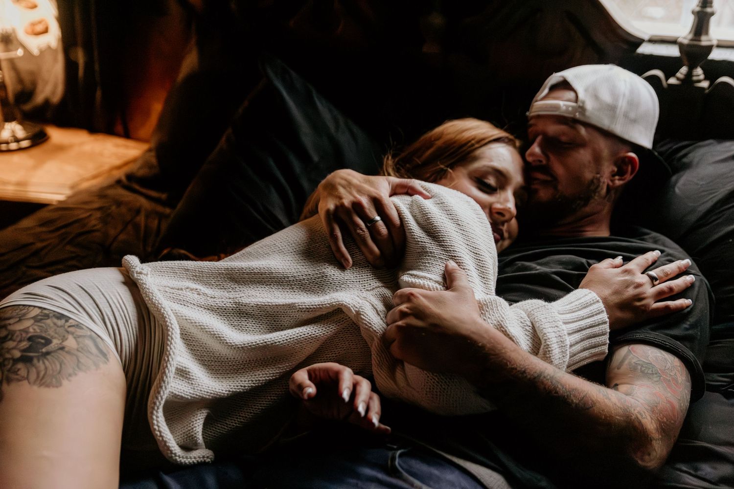 Two people embracing affectionately on a couch.