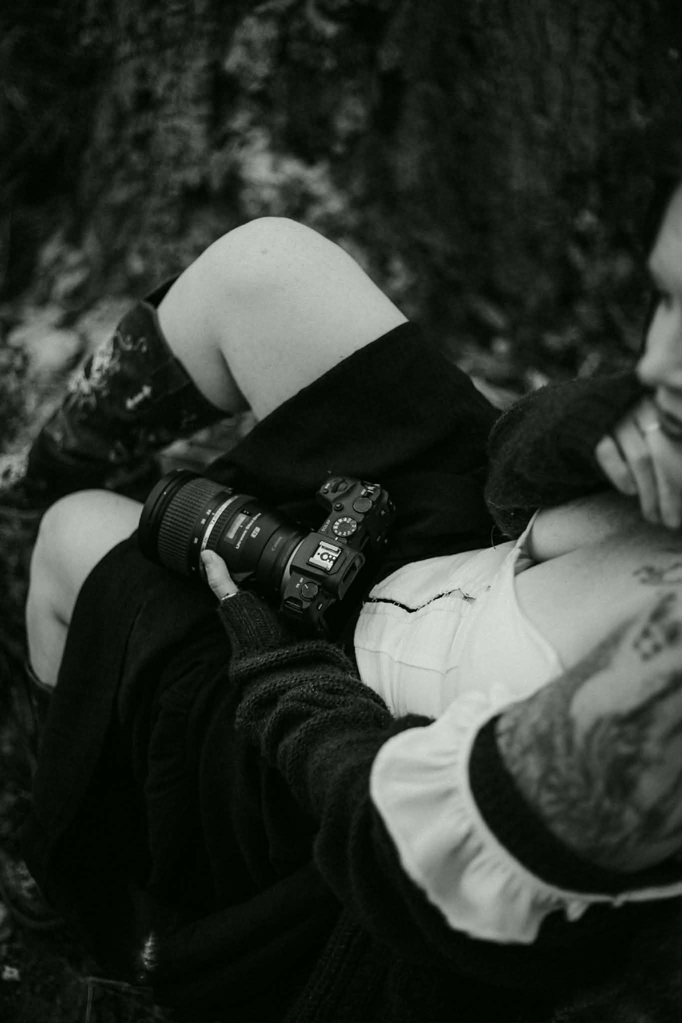 Close-up black and white photo showing hands and casual clothing details.