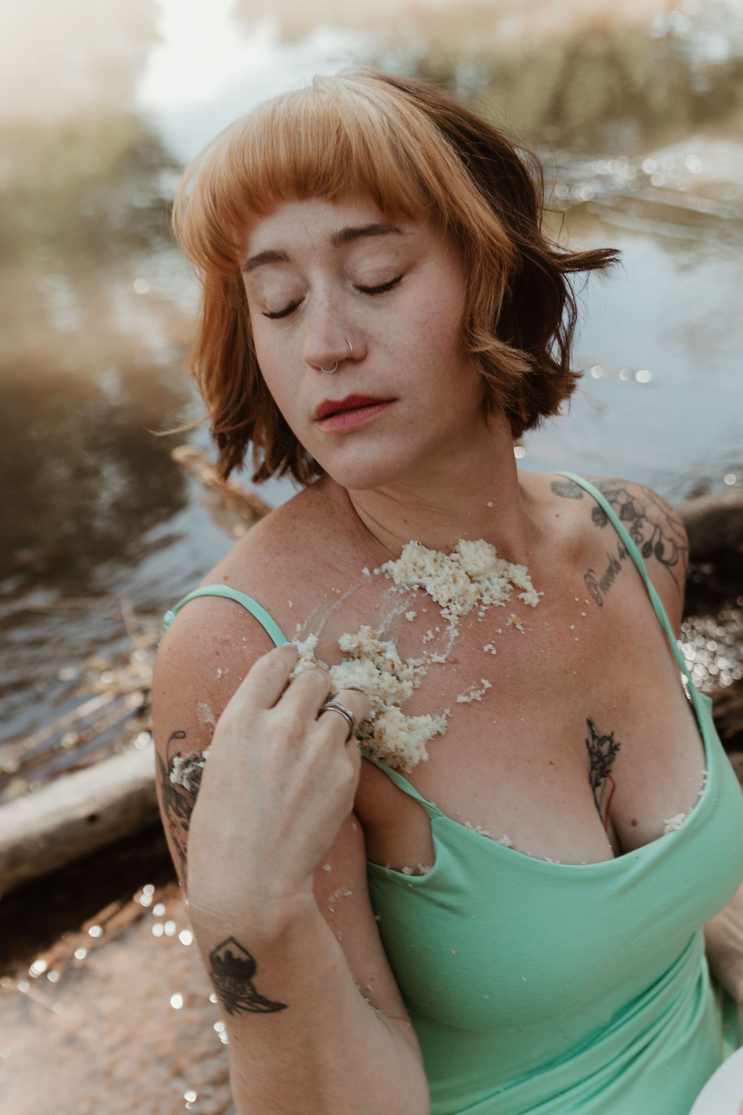Artistic portrait in mint green tank top with delicate white flowers against dreamy outdoor backdrop.