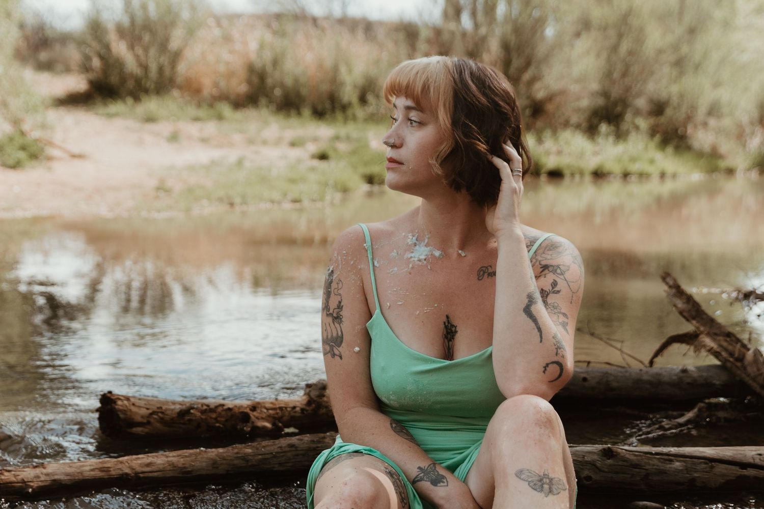 A series of outdoor family photos captured by a lake with natural lighting and fallen logs.