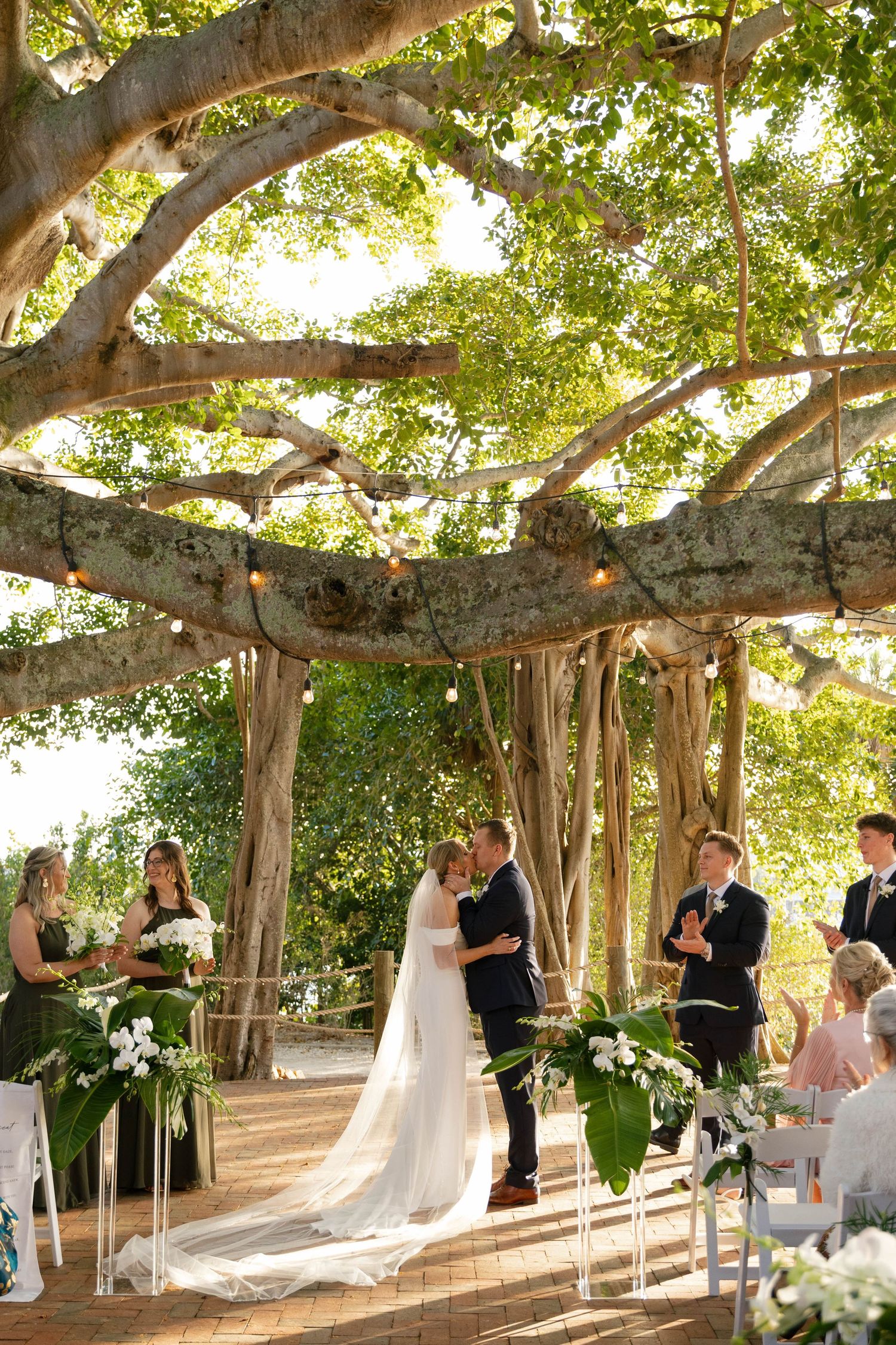 Romantic Jupiter, Florida wedding ceremony surrounded by tropical banyan trees at the historic Jupiter Inlet Lighthouse
