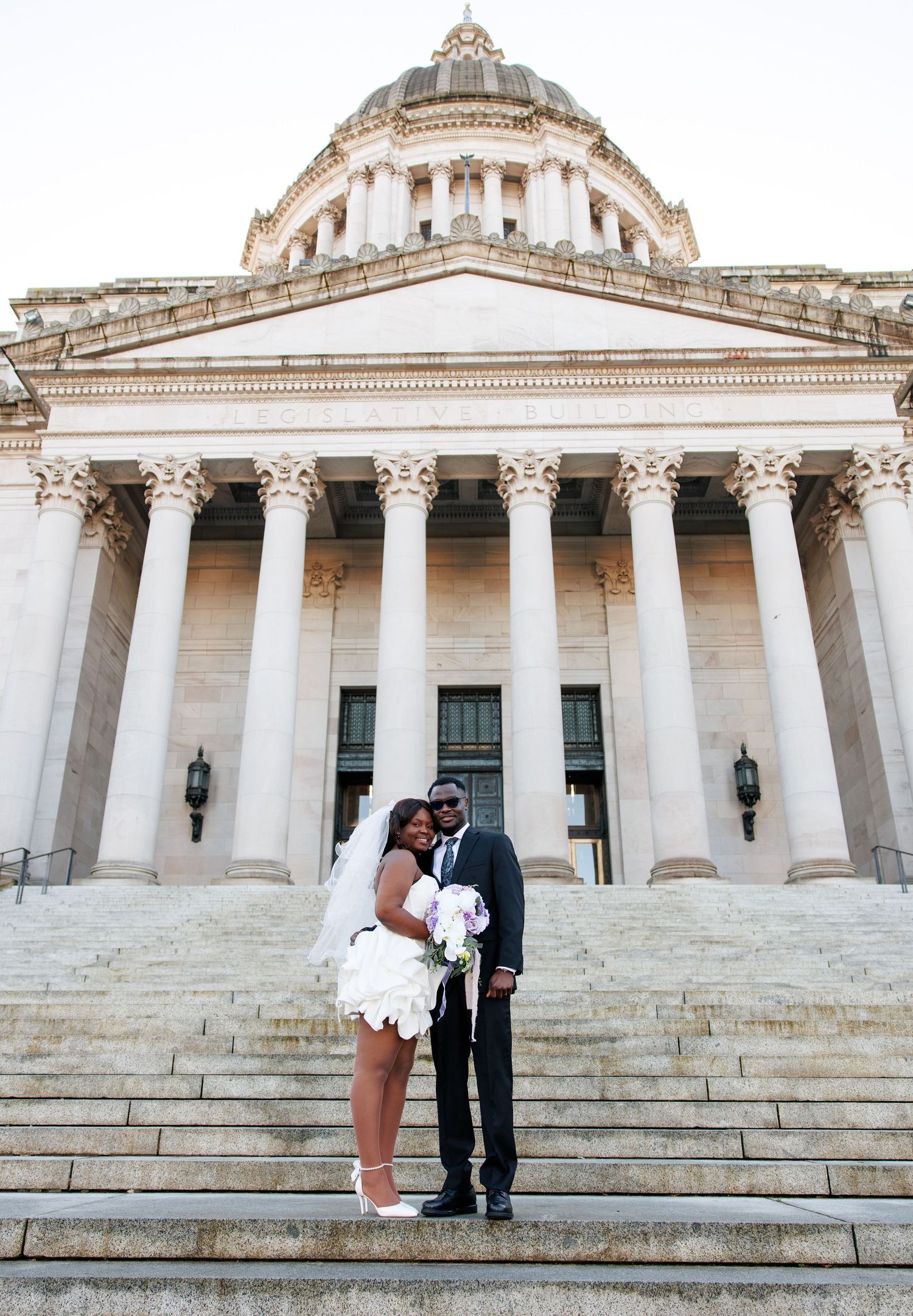 Newlyweds kissing on the steps of the Washington State Capitol in Olympia