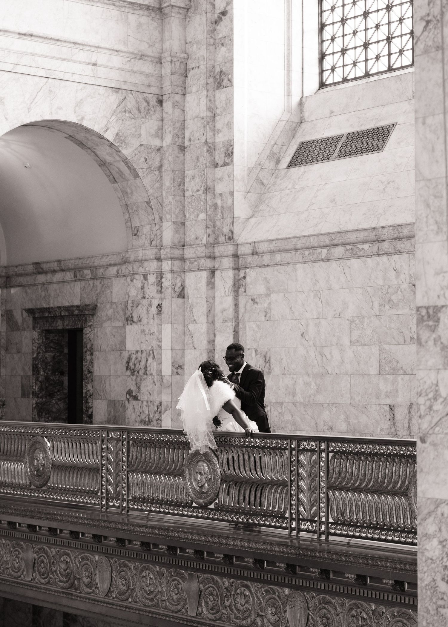 Newlyweds sharing a quiet moment on a balcony inside the Washington State Capitol in Olympia