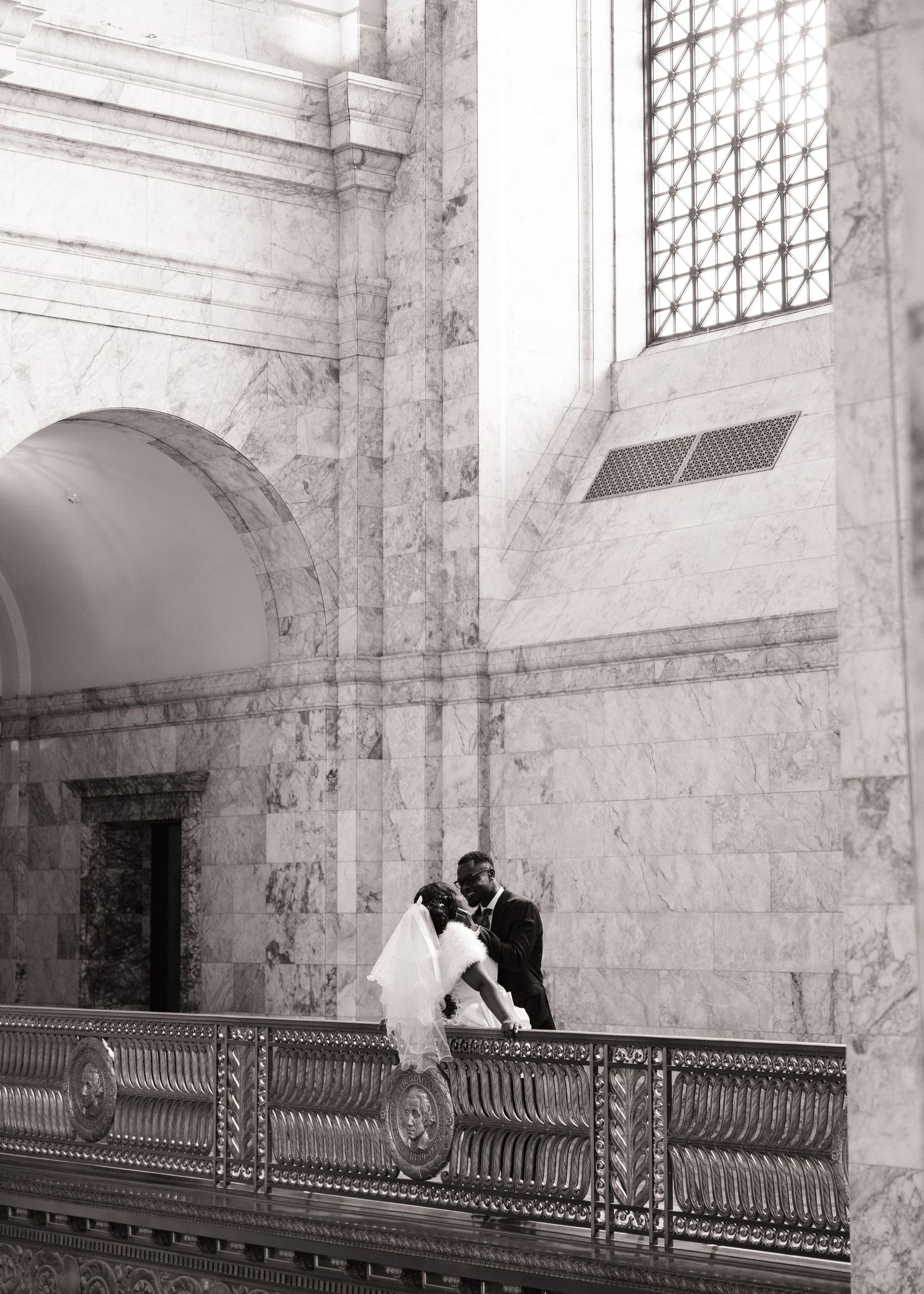 Newlyweds embracing beneath the marble architecture of the Washington State Capitol in Olympia