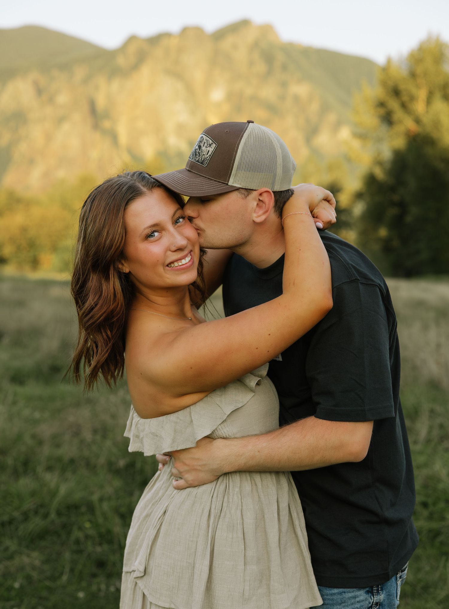 Couple sharing a kiss during a golden hour mountain couples photography session in Washington.