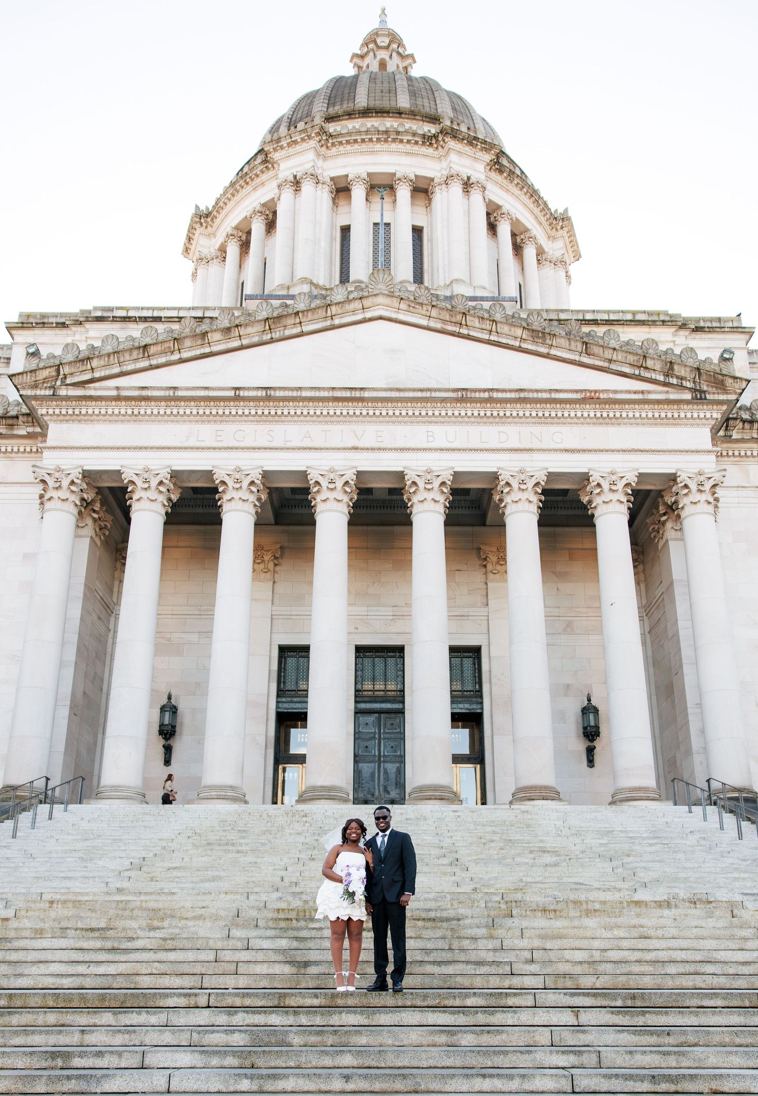 Bride and groom standing together in front of the Washington State Capitol in Olympia