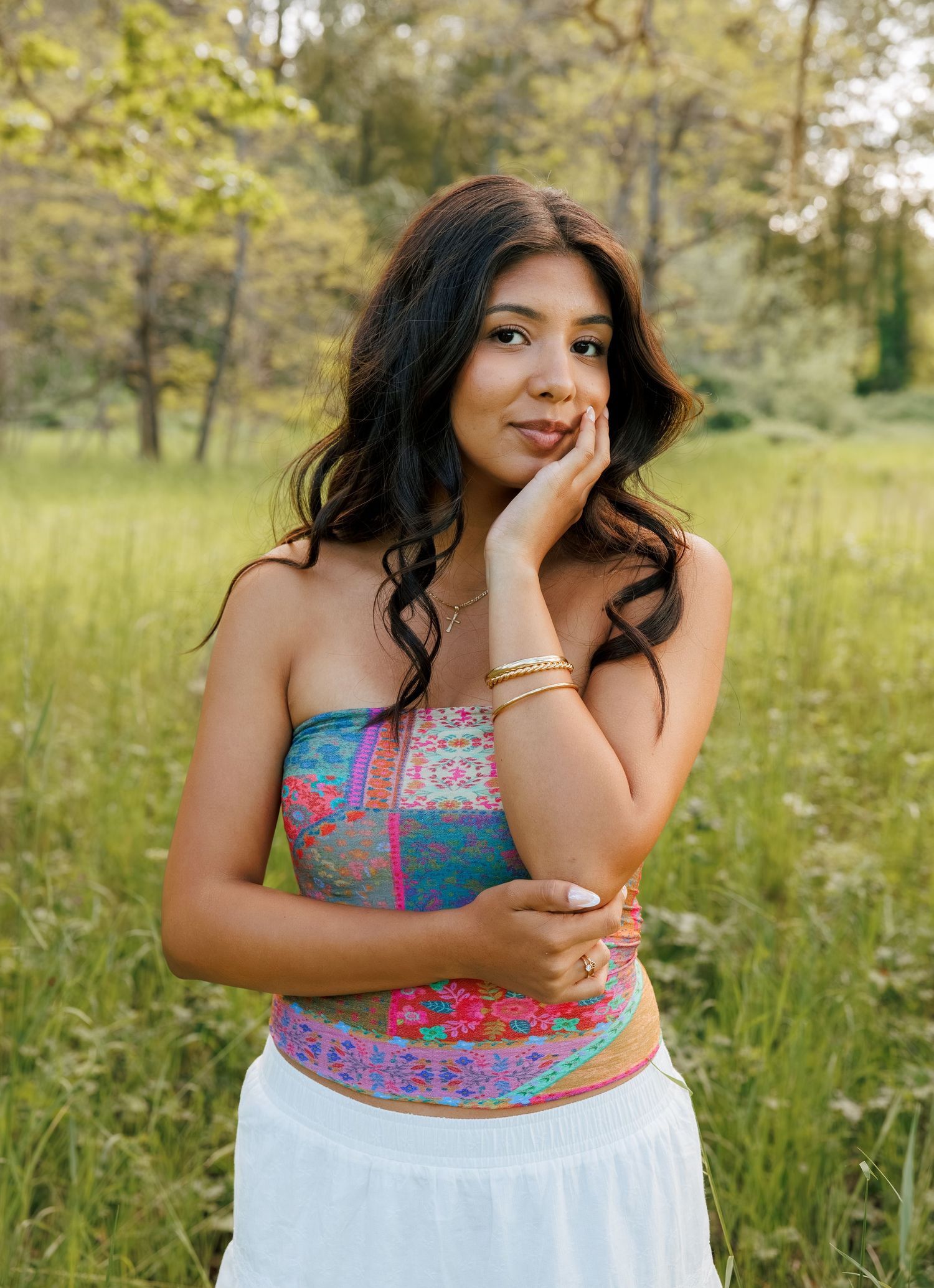 Senior girl posing in a grassy field during a natural outdoor senior photography session in Washington.
