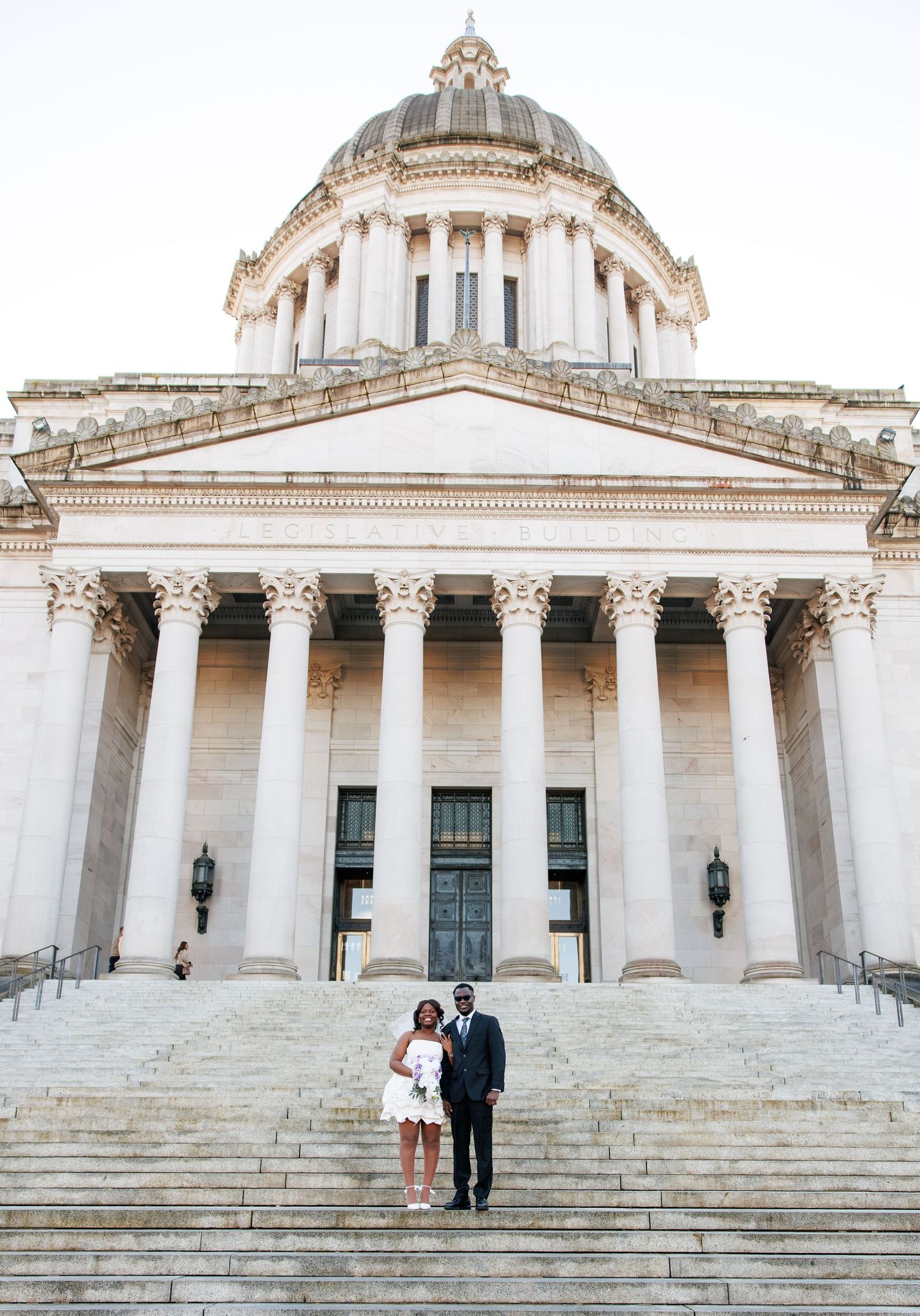 Bride and groom standing beneath the Washington State Capitol dome in Olympia