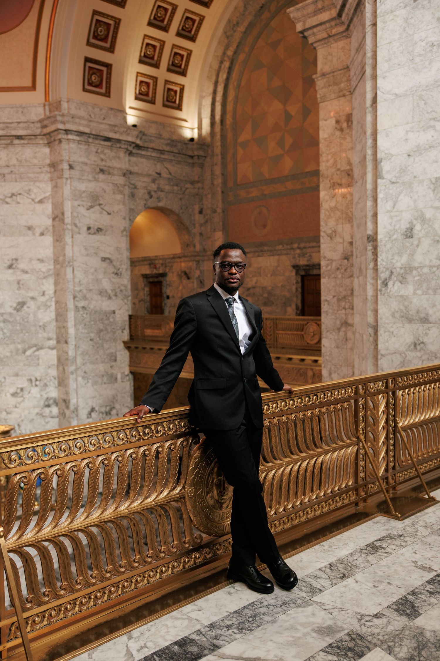 Groom posing beside the ornate railing inside the Washington State Capitol in Olympia