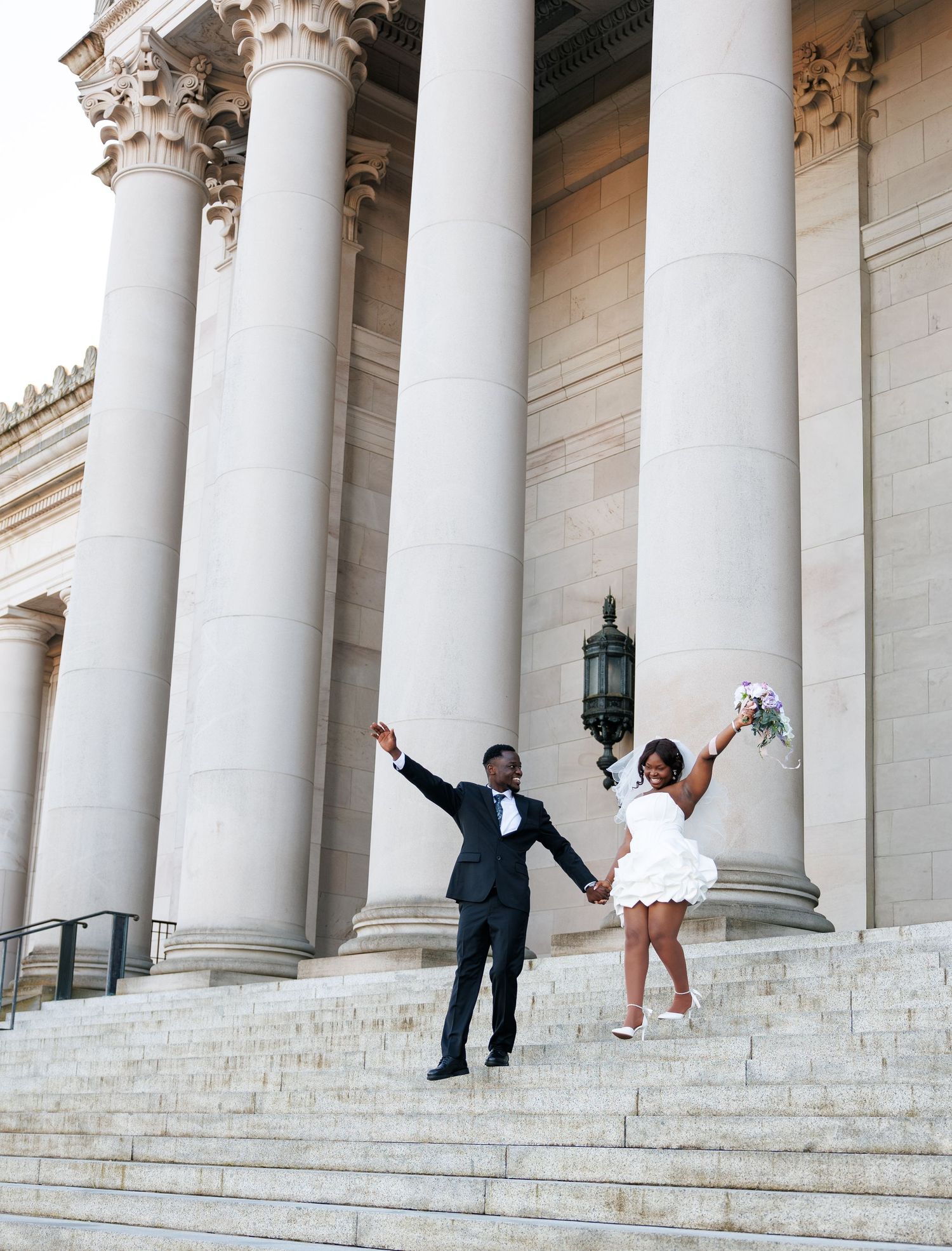 Newlyweds celebrating beneath the grand columns of the Washington State Capitol in Olympia