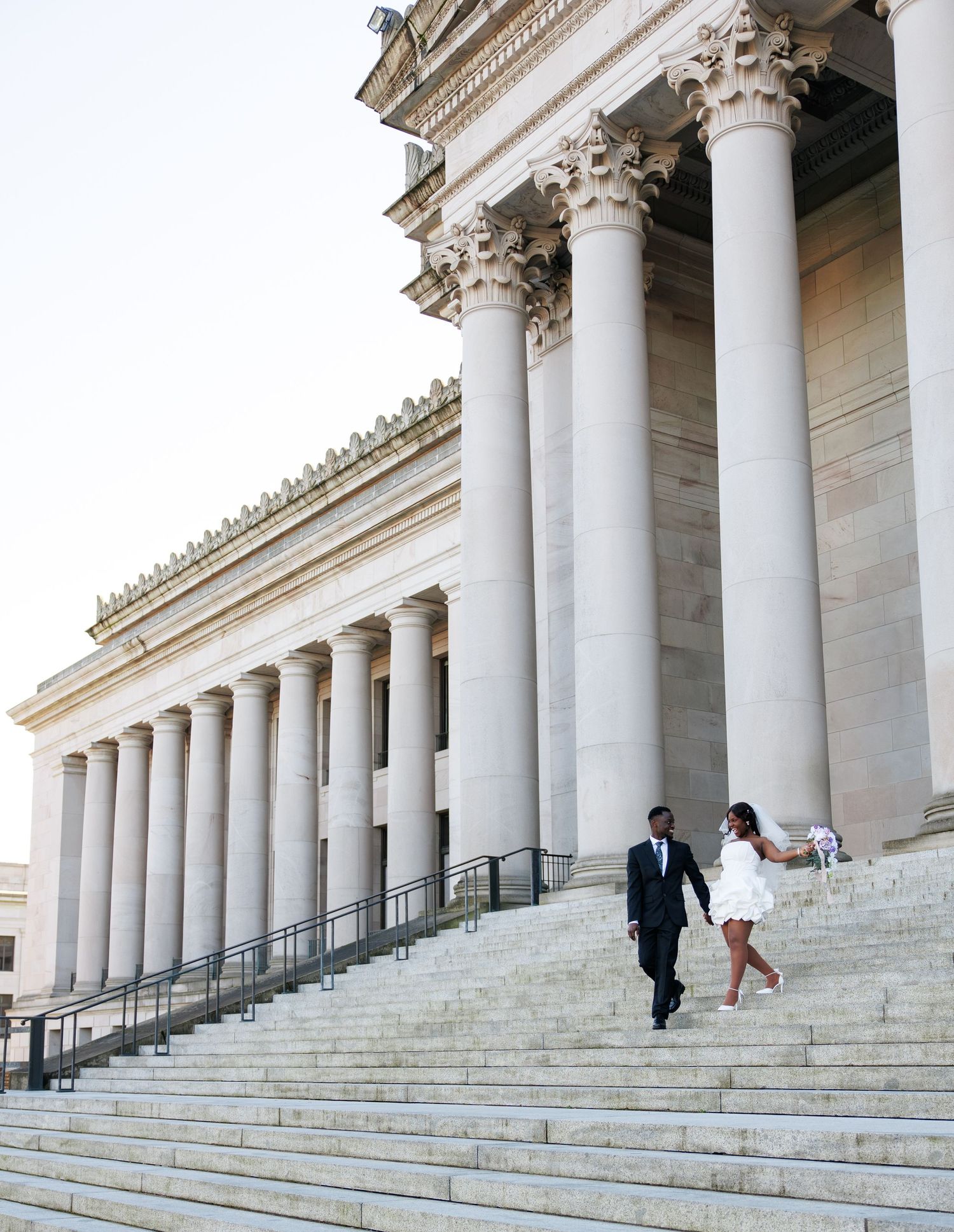 Bride and groom walking down the Washington State Capitol steps during their Olympia wedding