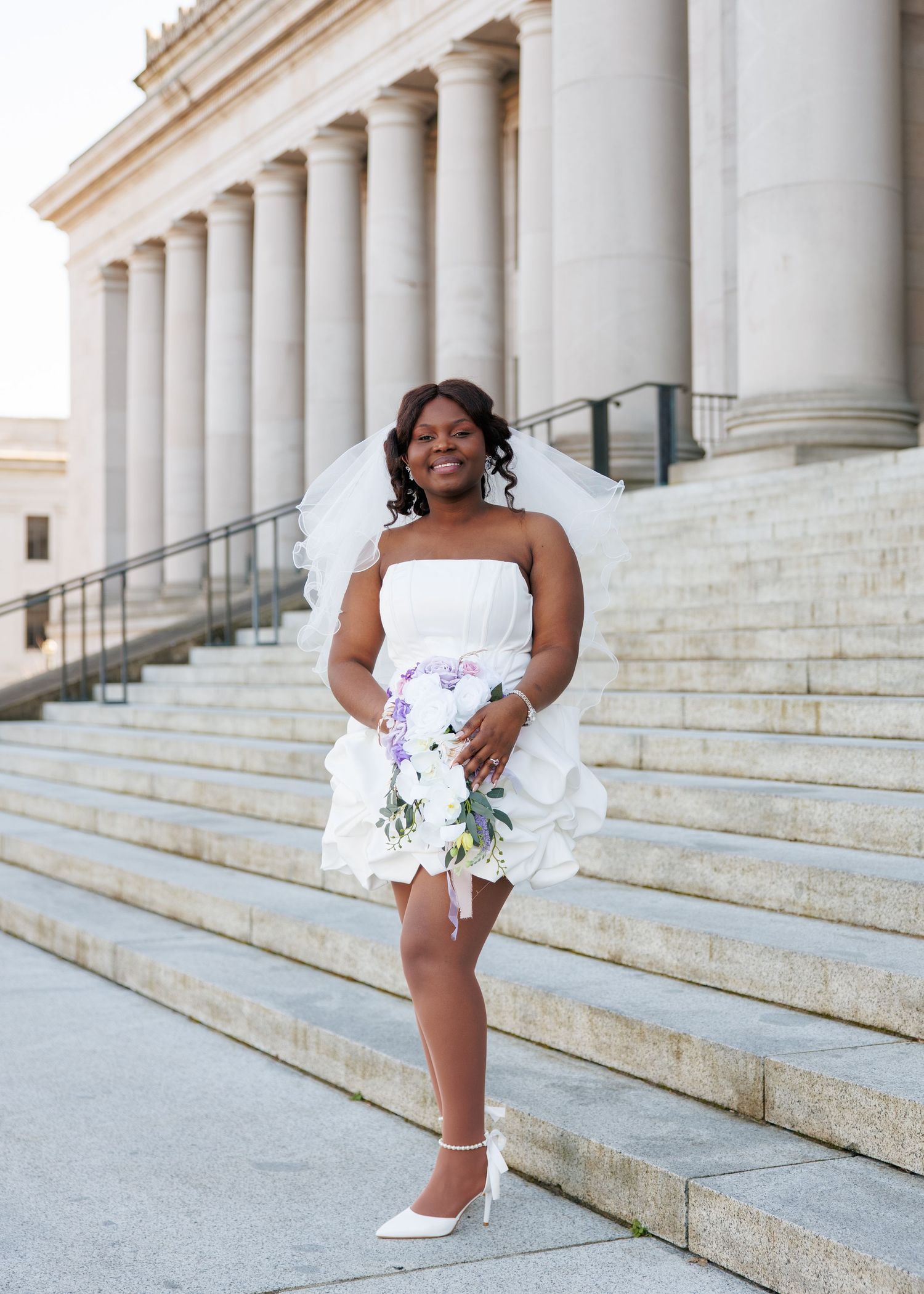 Bride smiling with her bouquet on the Washington State Capitol steps in Olympia